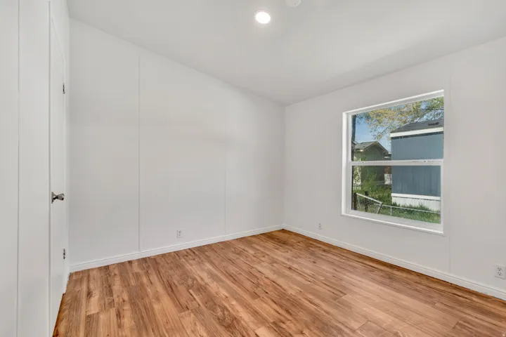 Empty room featuring light wood-style flooring, recessed lighting, and a decorative wall
