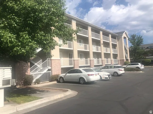 View of apartment building / complex with uncovered parking