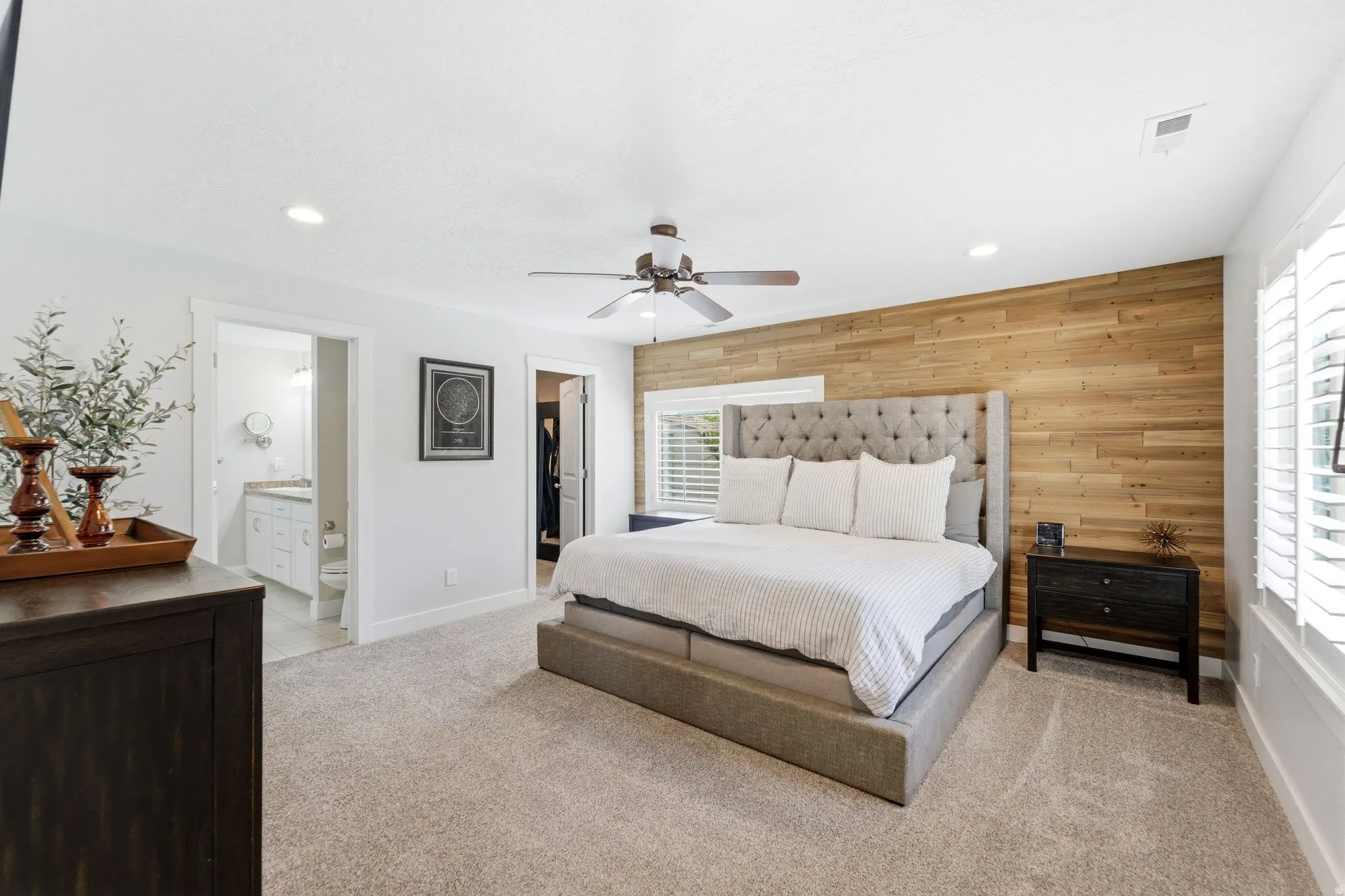 Bedroom featuring a walk in closet, wooden walls, light carpet, recessed lighting, and a ceiling fan