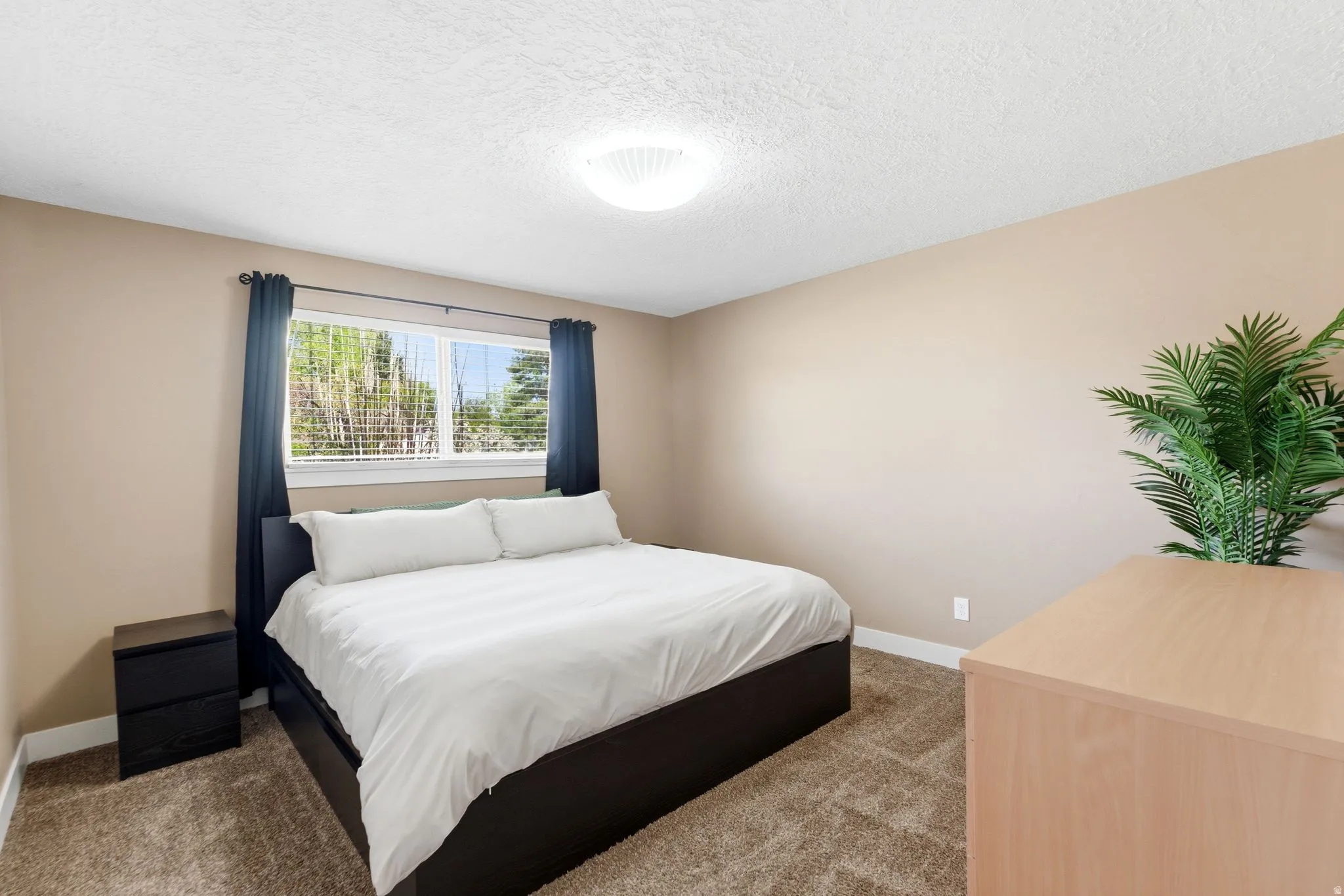 Carpeted bedroom with baseboards and a textured ceiling