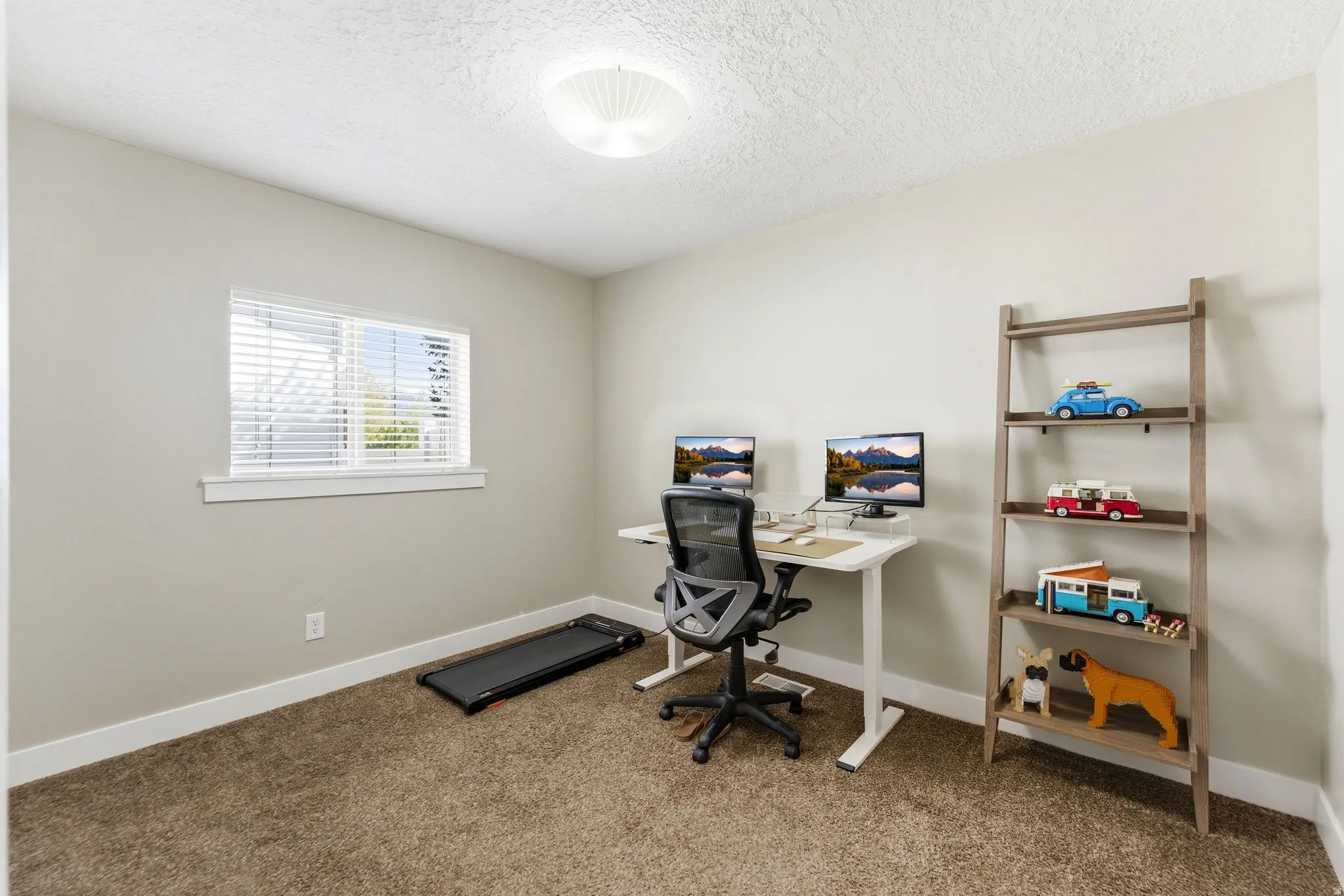 Office area with light colored carpet and a textured ceiling