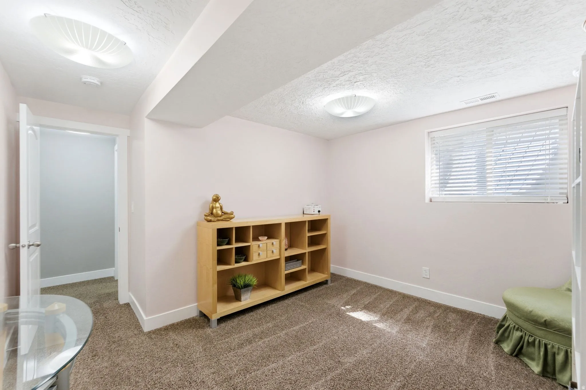 Miscellaneous room with dark carpet and a textured ceiling