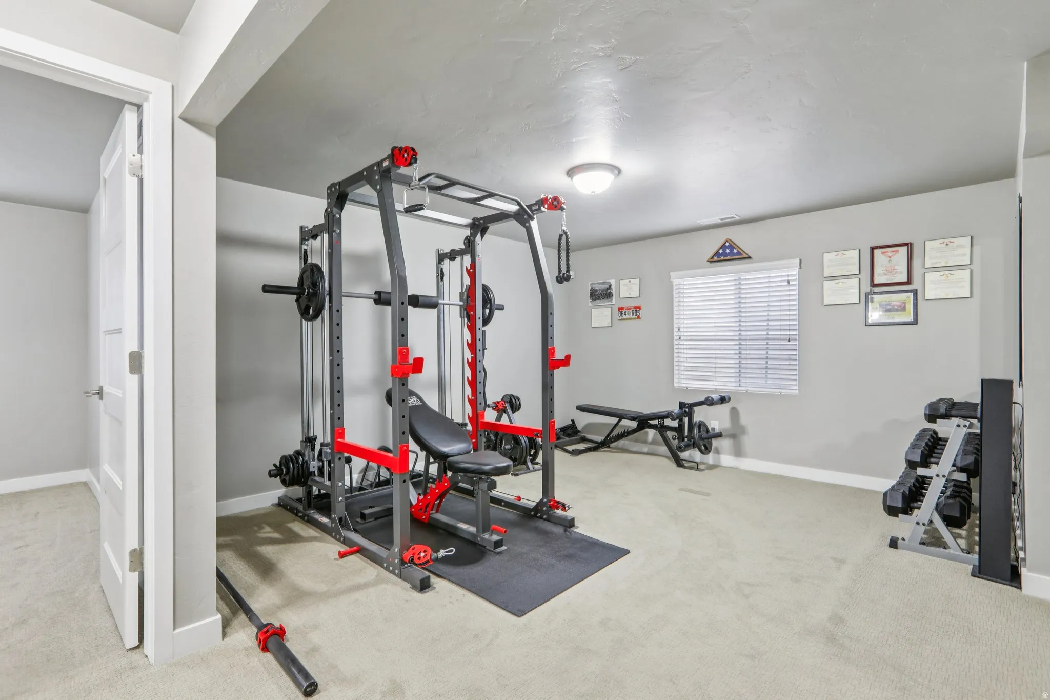 Exercise area with light colored carpet and baseboards