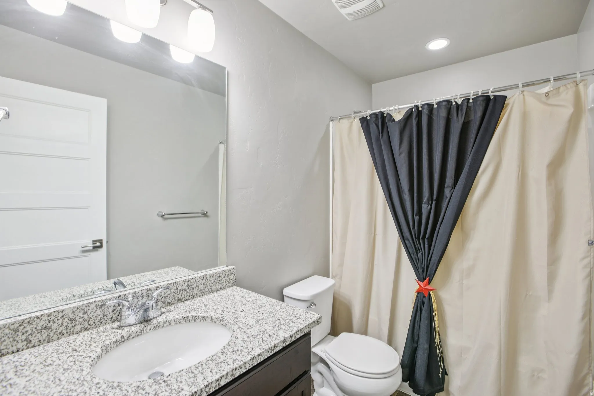 Full bath with vanity and a shower with shower curtain