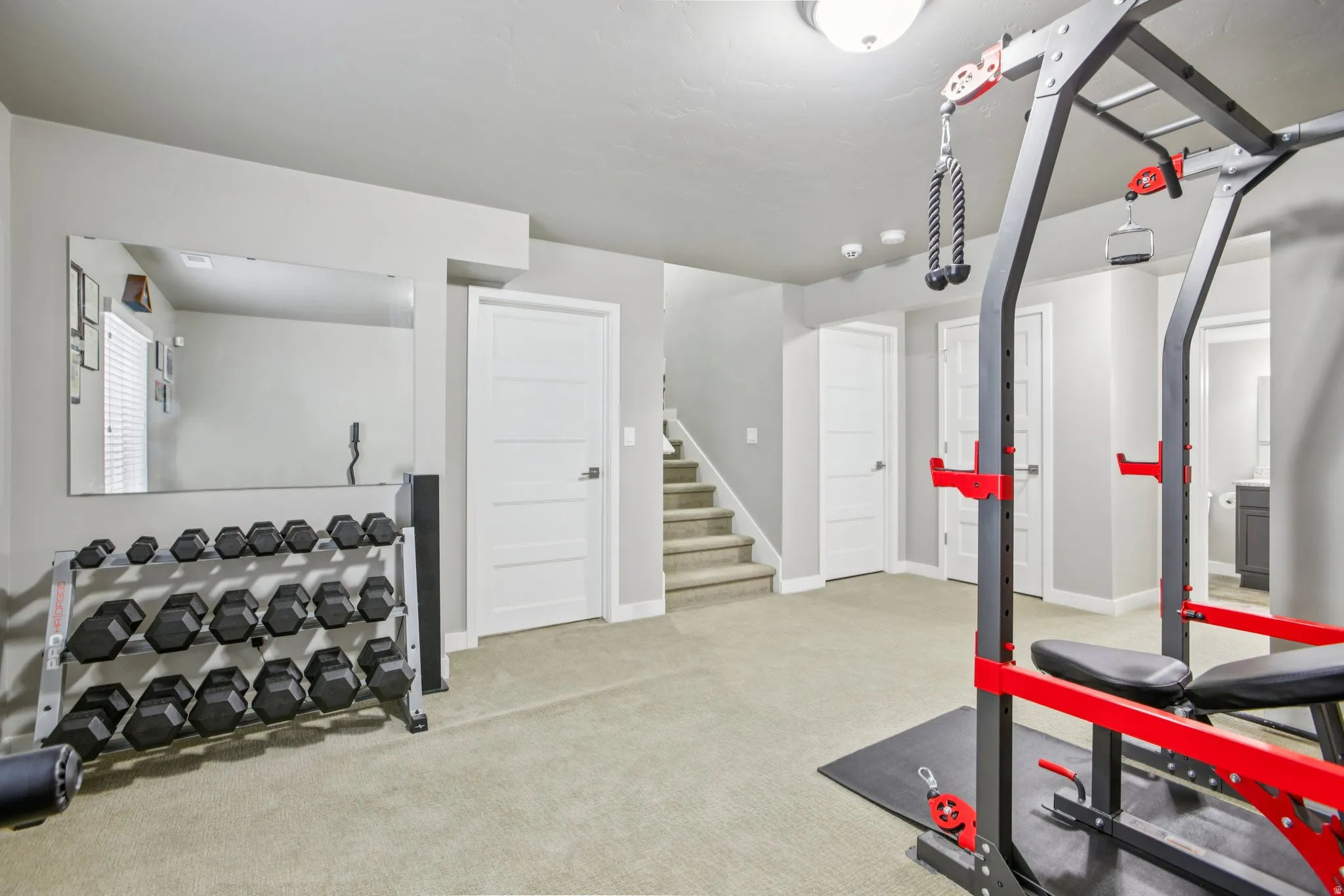 Workout area featuring light carpet and baseboards