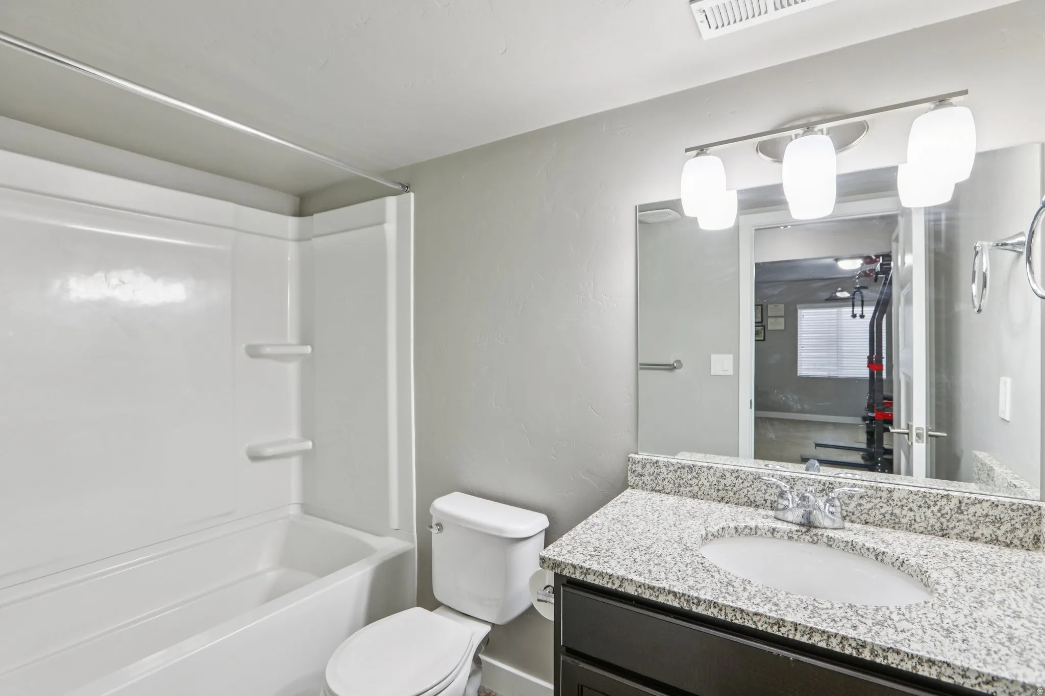 Full bath with vanity, shower / washtub combination, and a textured wall
