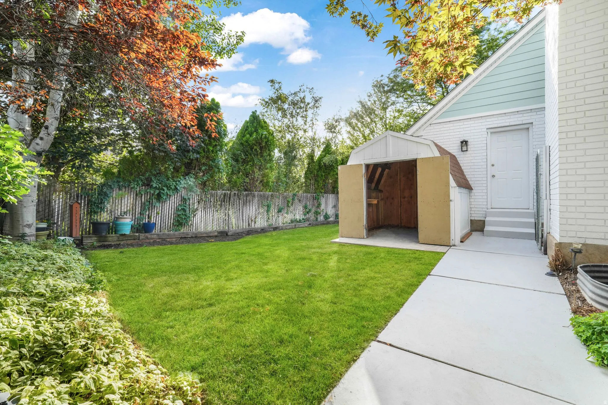 Fenced backyard with a storage shed