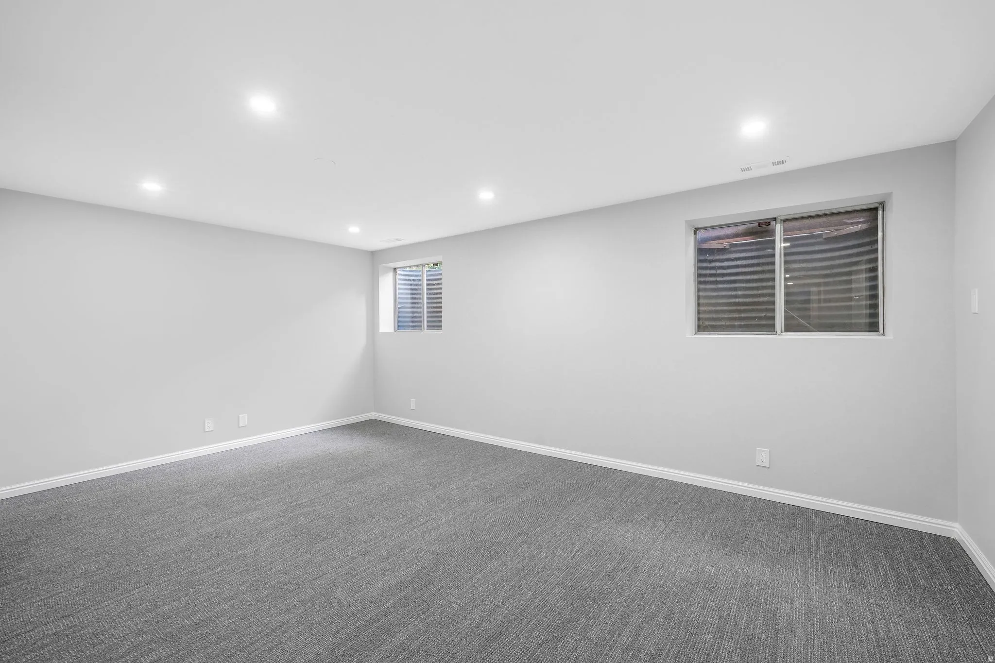 Empty room featuring recessed lighting and dark carpet