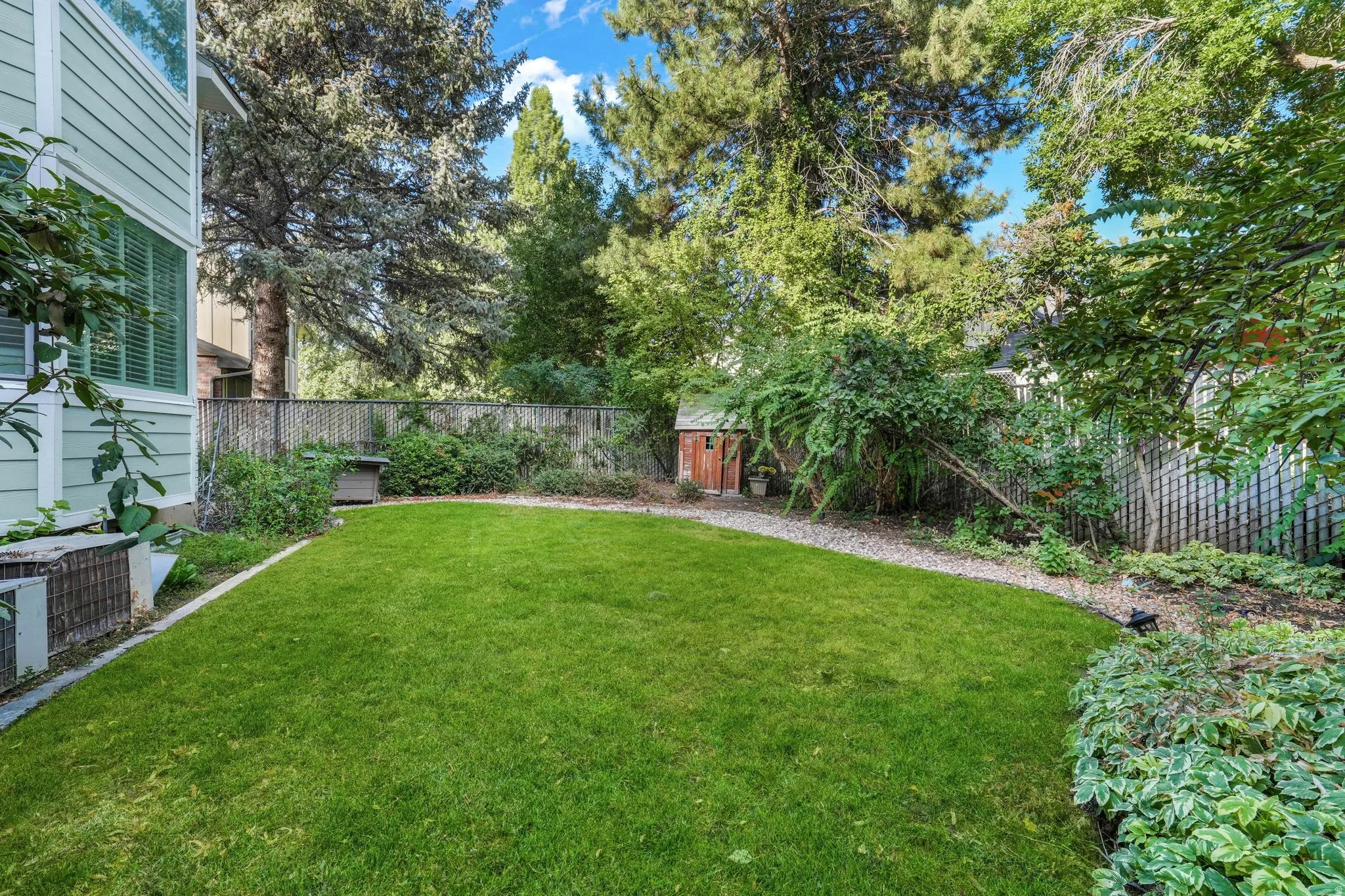 Fenced backyard featuring an outdoor structure