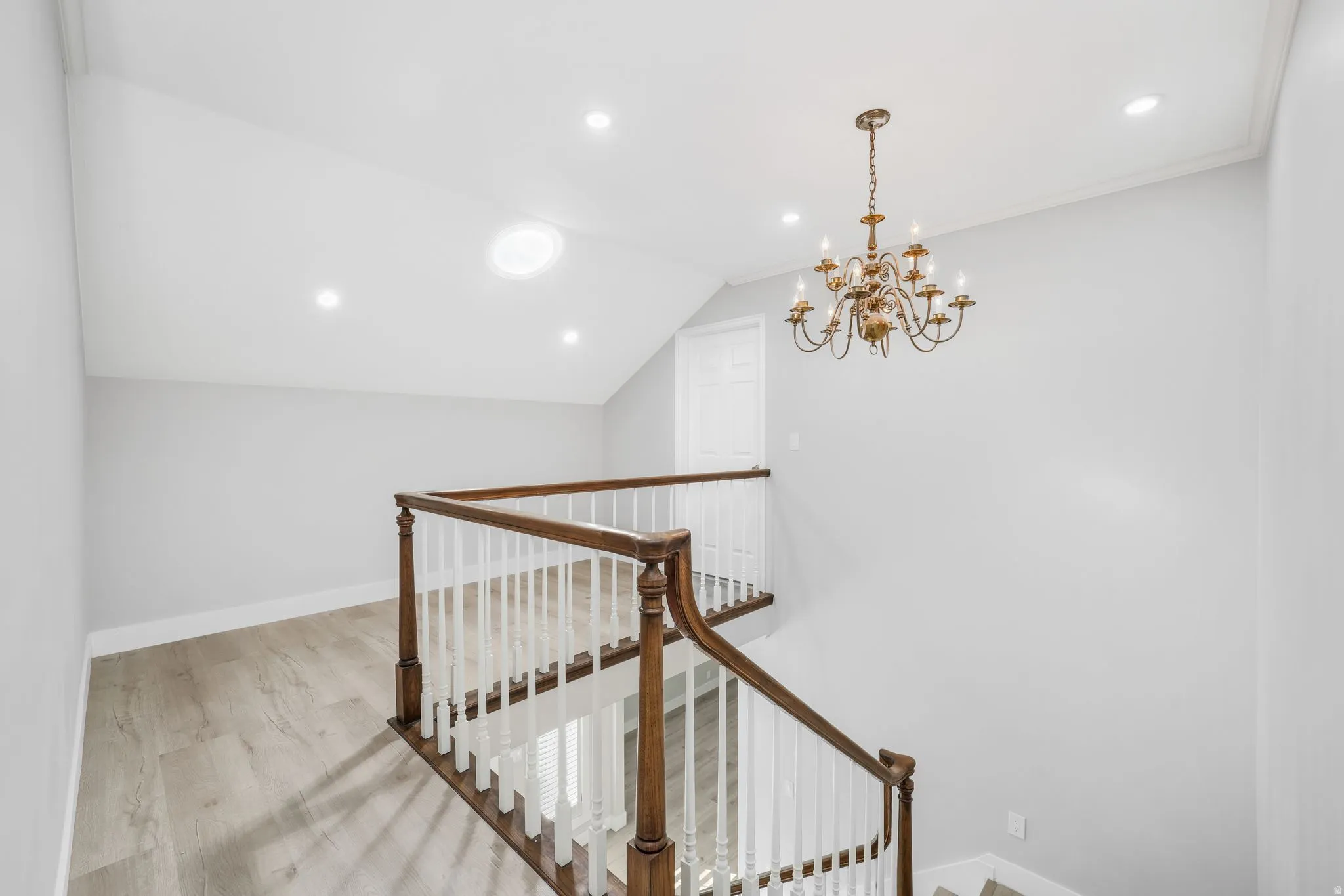 Stairs featuring a chandelier and wood finished floors