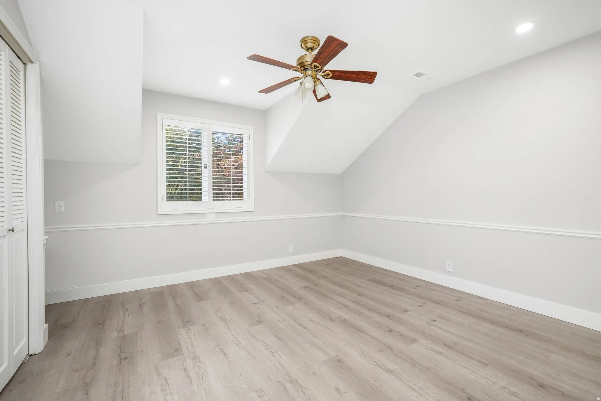 Additional living space with a ceiling fan, light wood-style floors, vaulted ceiling, and recessed lighting