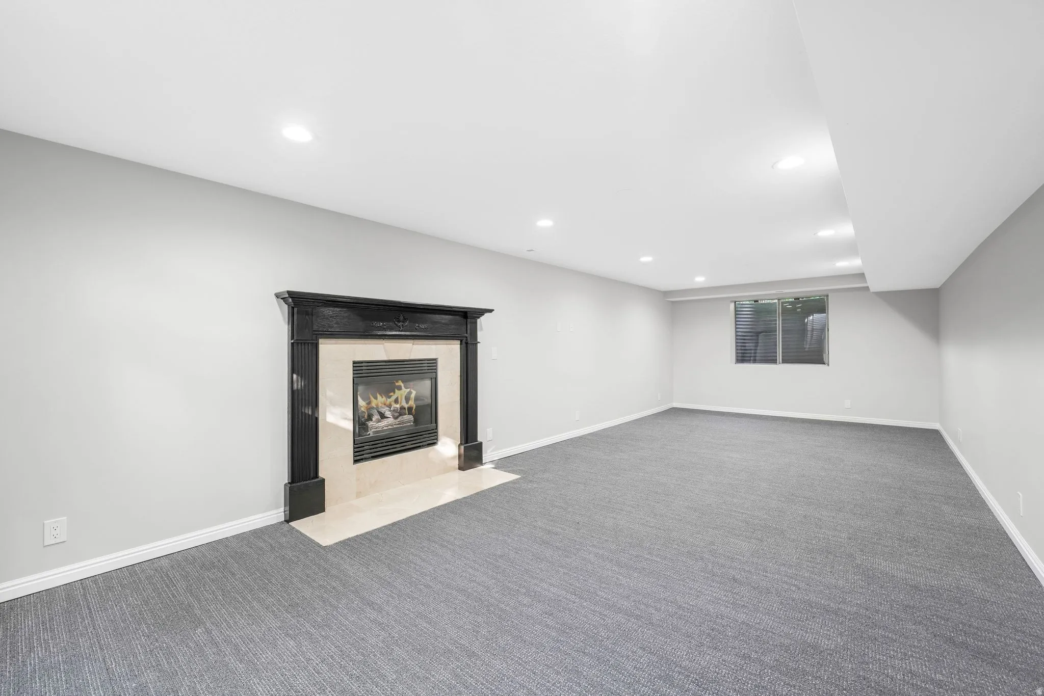 Finished basement with carpet, a tiled fireplace, and recessed lighting