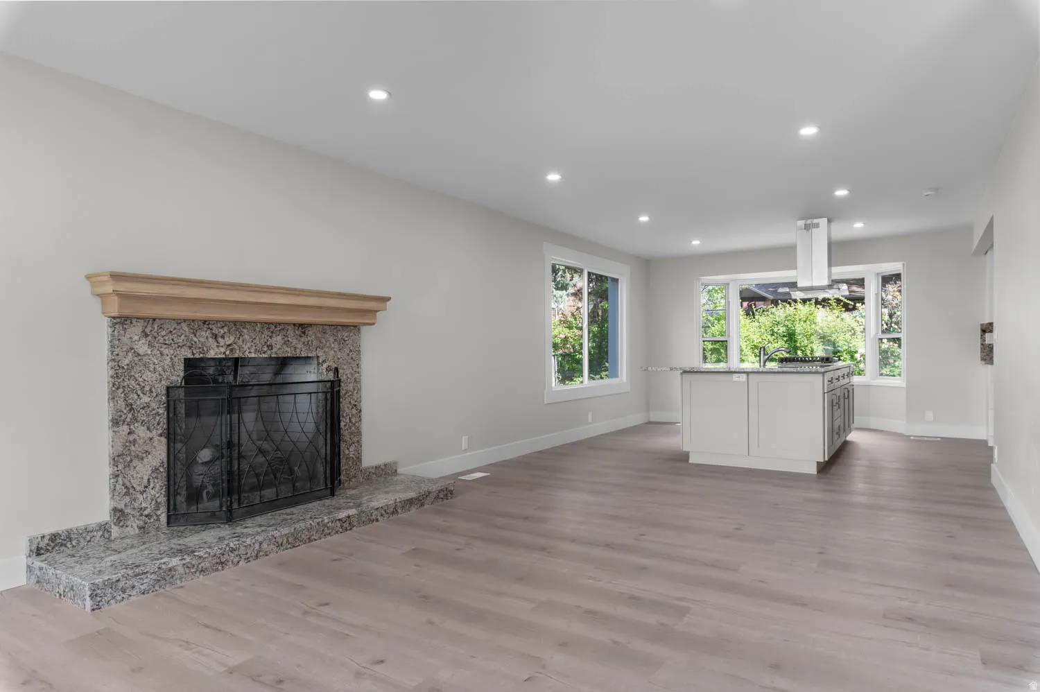 Unfurnished living room featuring recessed lighting, light wood finished floors, and a fireplace