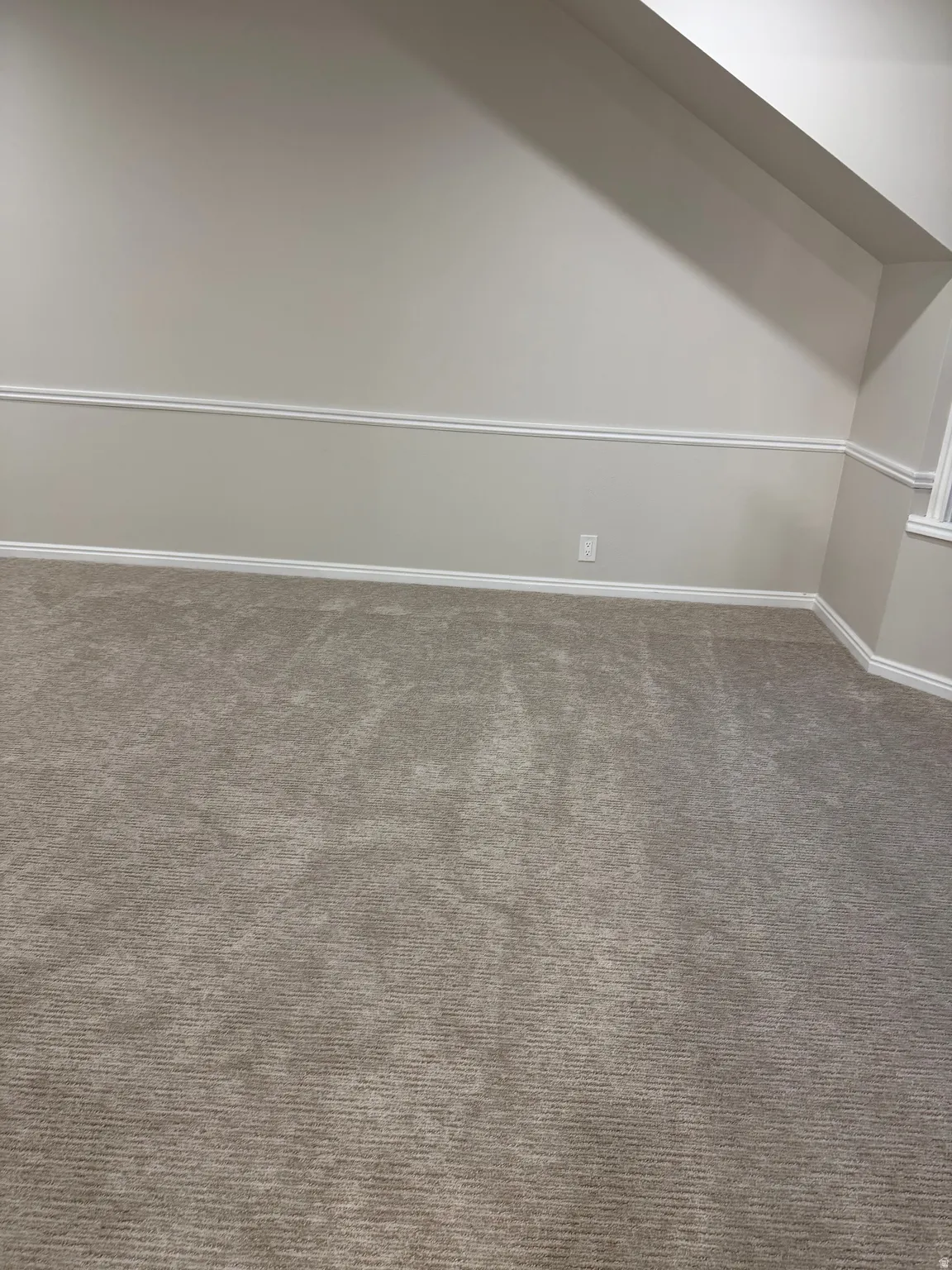 Bonus room with dark carpet and baseboards