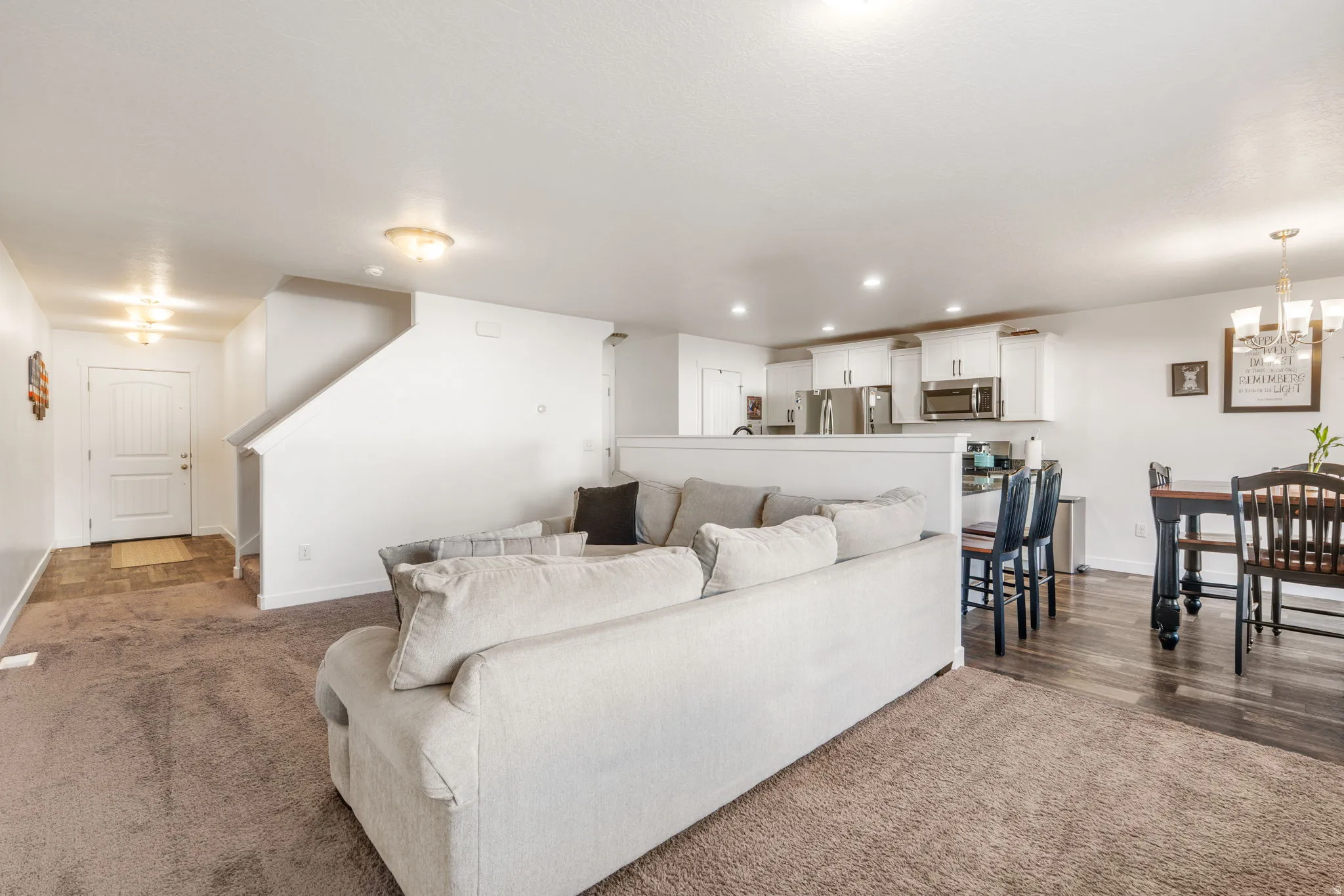 Living area featuring hanging lights and dark carpet