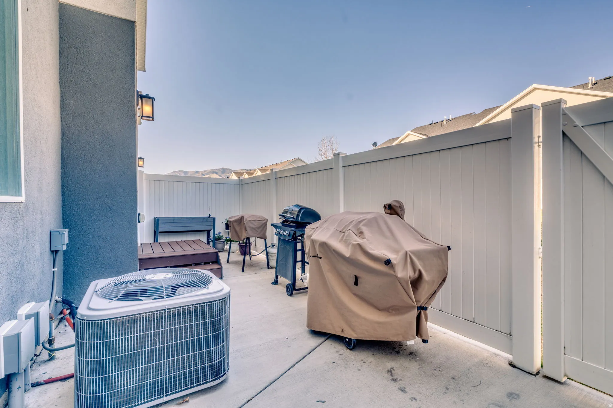 Fenced backyard with a grill and a patio