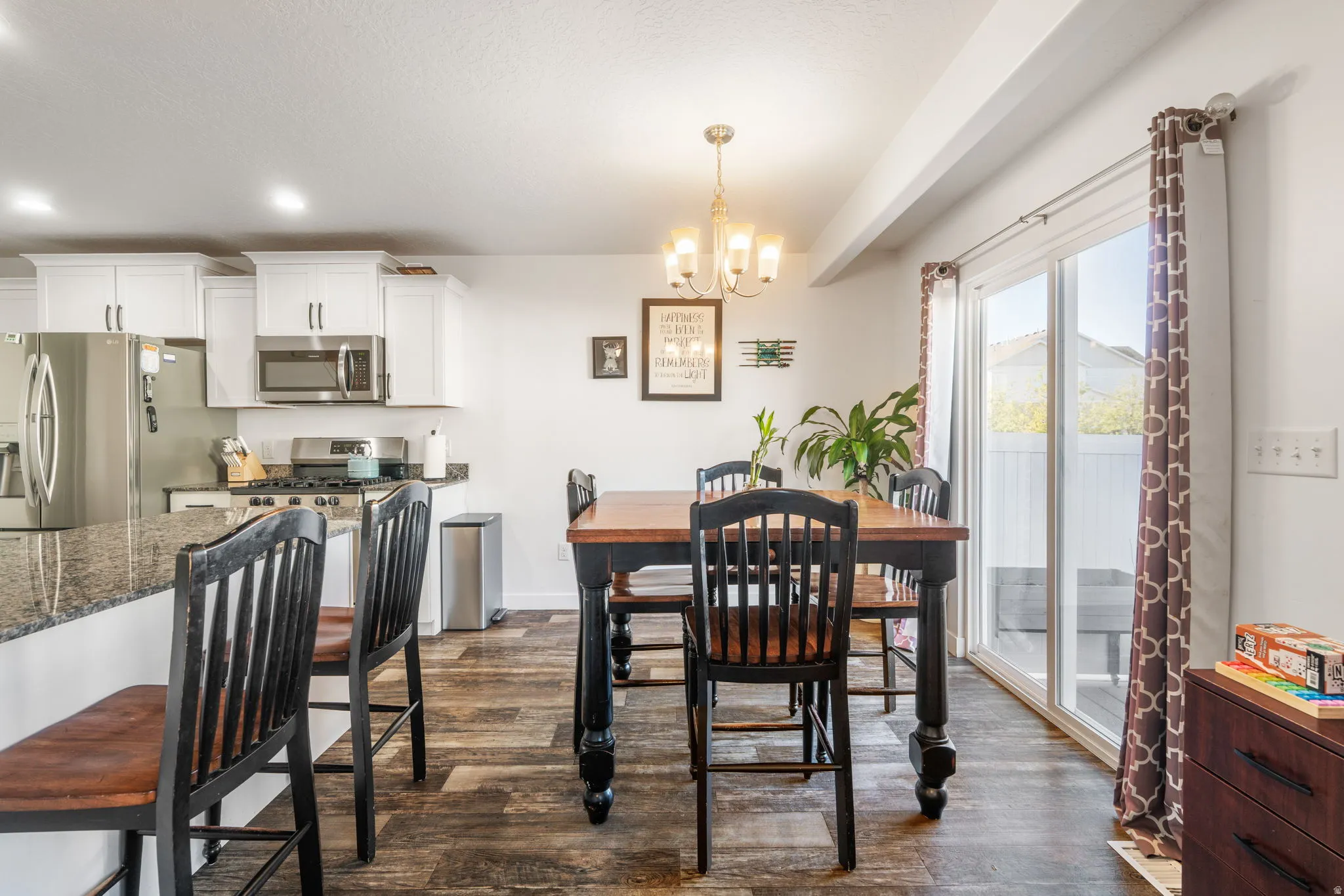 Dining room with a chandelier and dark wood-style floors
