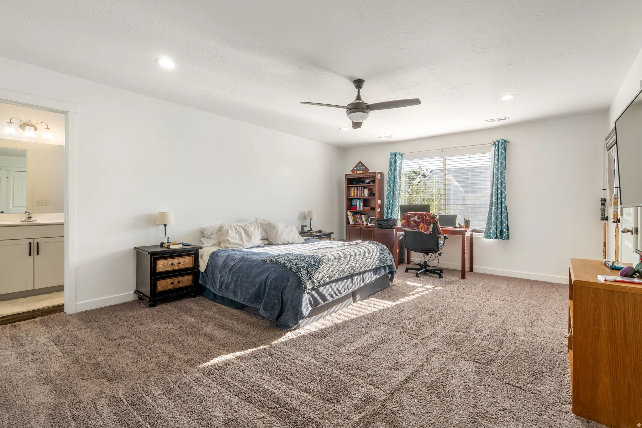 Bedroom featuring dark carpet, a ceiling fan, a desk, recessed lighting, and ensuite bath