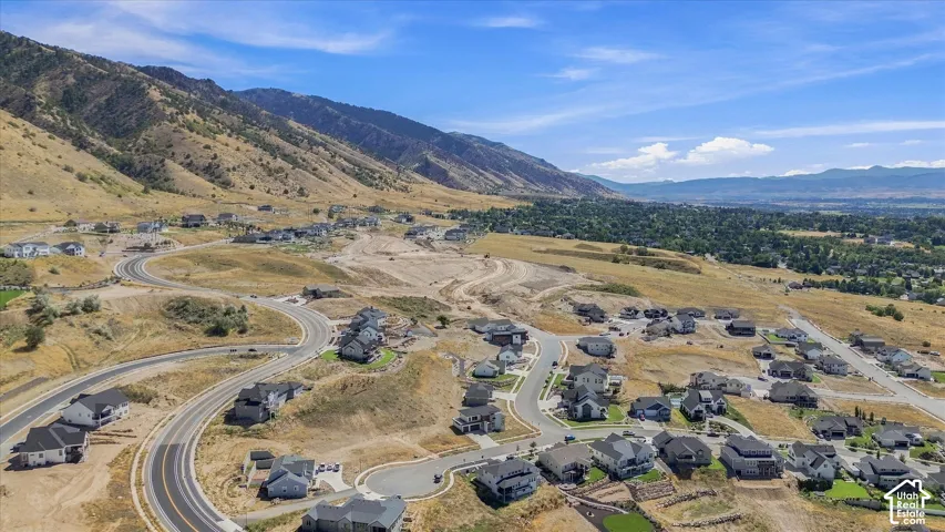 Expansive mountain backdrop with a valley panorama featuring residential developments