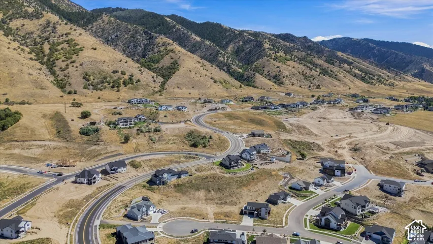 Expansive residential development nestled against a mountain backdrop, featuring paved roads and cul-de-sacs