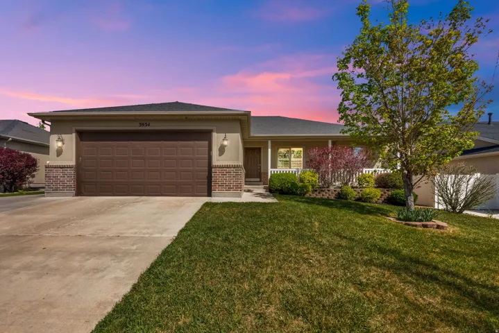 Single story home with brick siding, driveway, a garage, and a porch