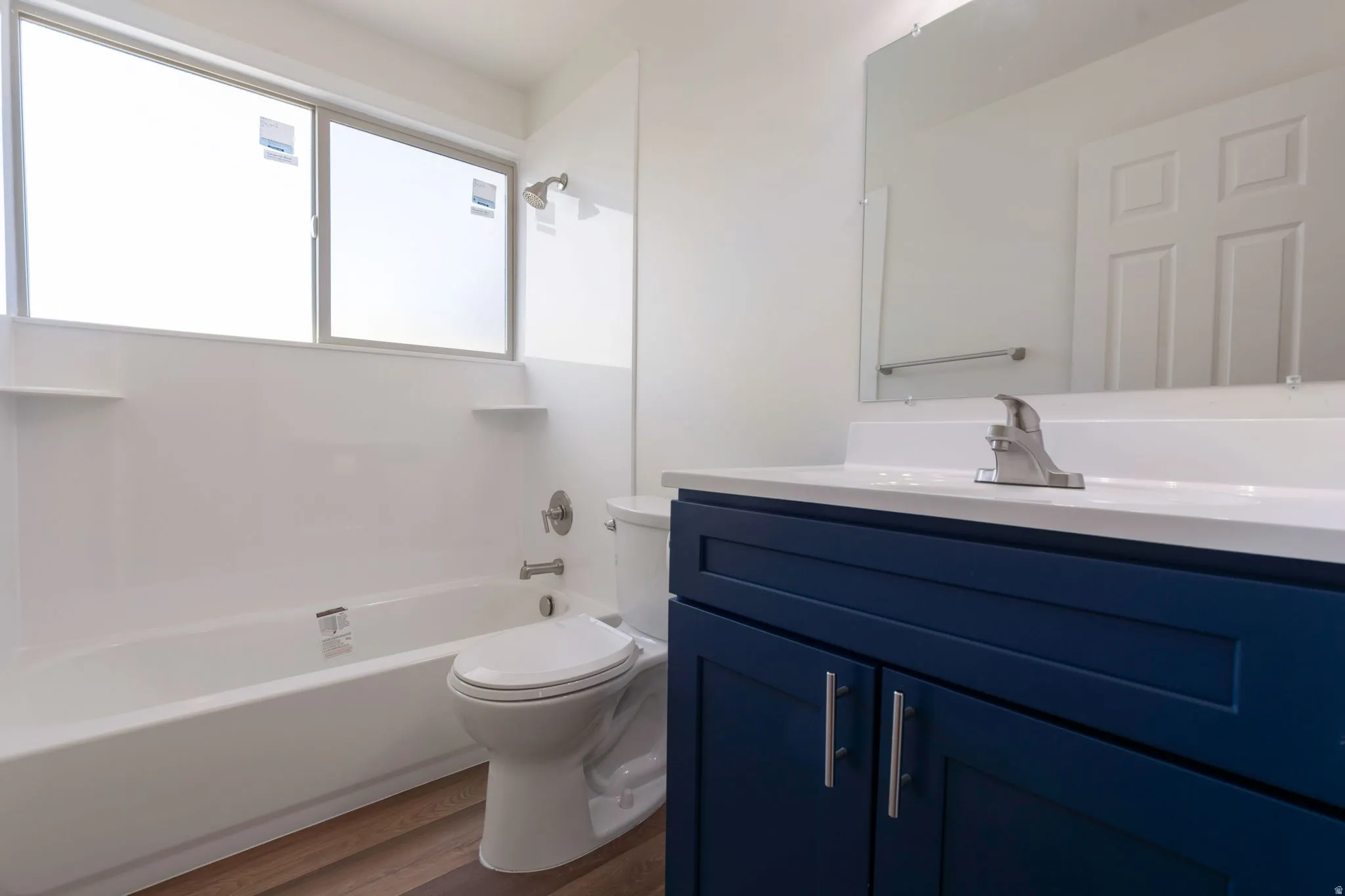 Bathroom featuring vanity, bathtub / shower combination, and dark wood-type flooring