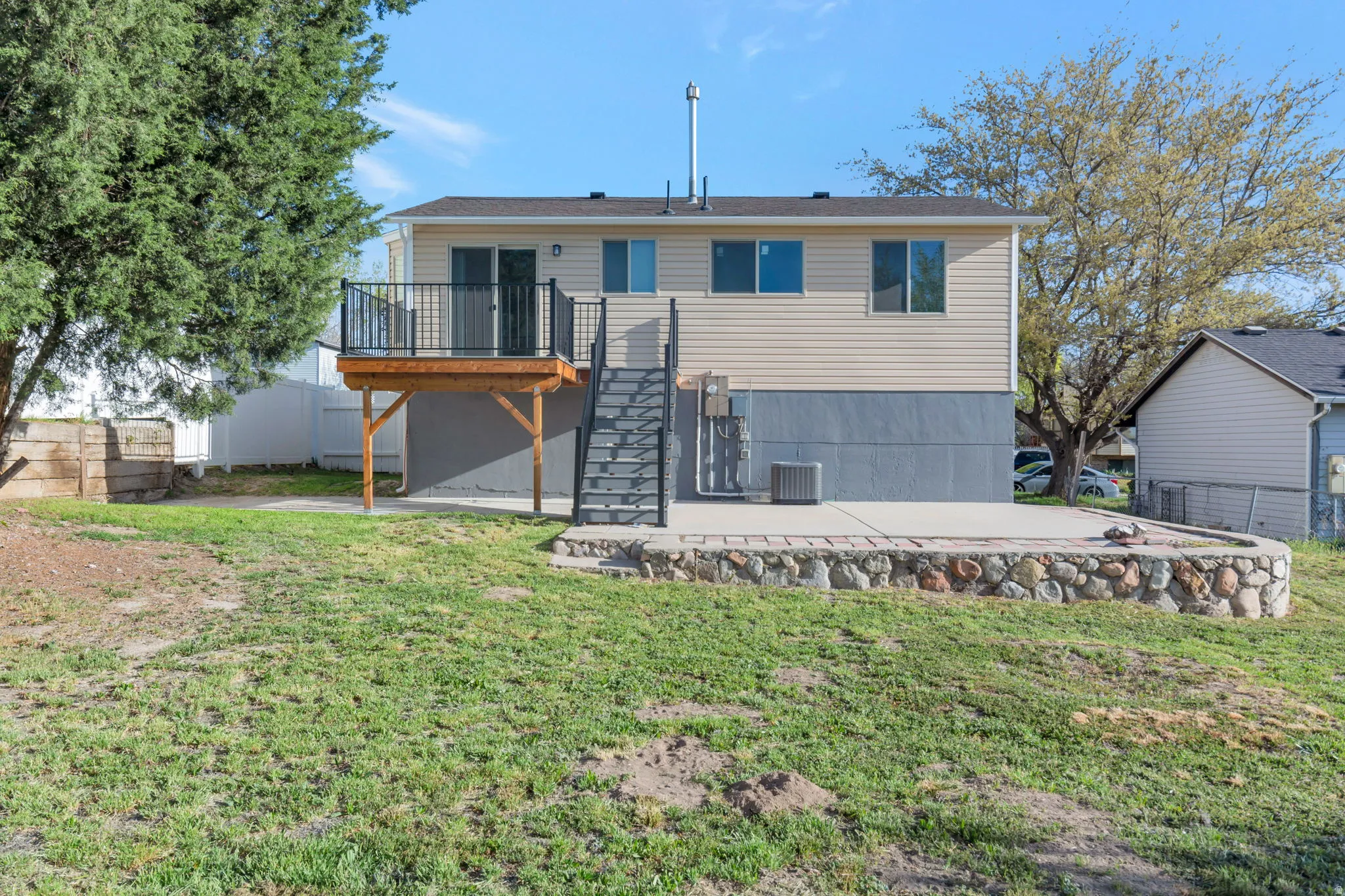 Back of property featuring a patio and a wooden deck