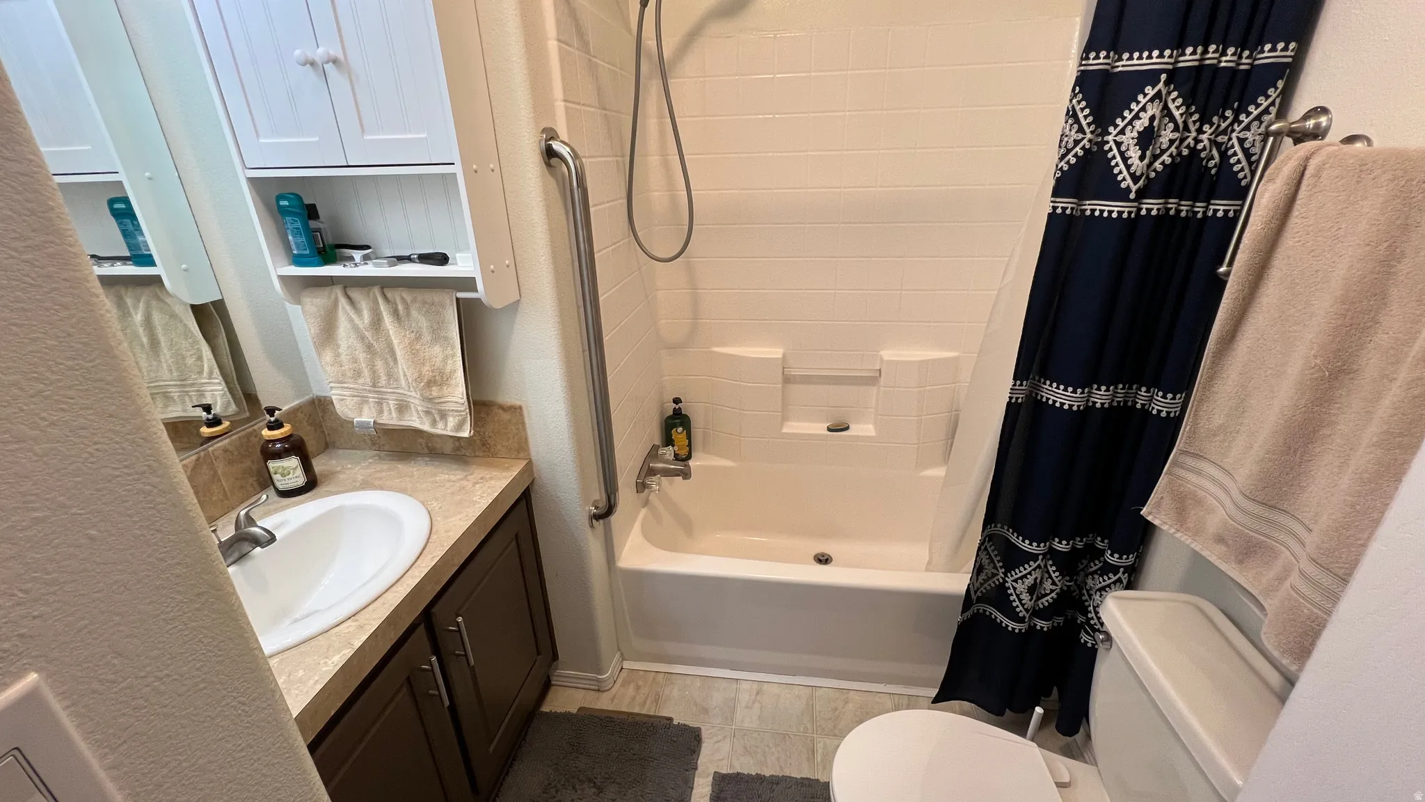 Primary Bathroom with vanity, shower / tub combo with curtain.