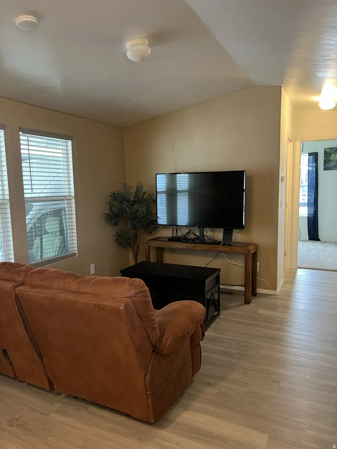 Interior living space featuring light wood-finish flooring, neutral wall tones, and overhead lighting