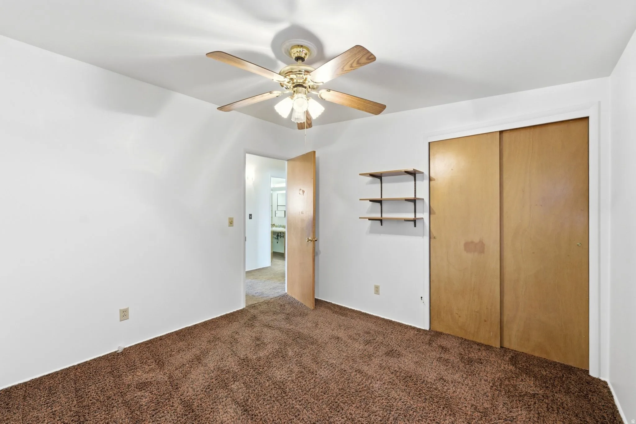 Unfurnished bedroom featuring carpet flooring, a closet, and ceiling fan