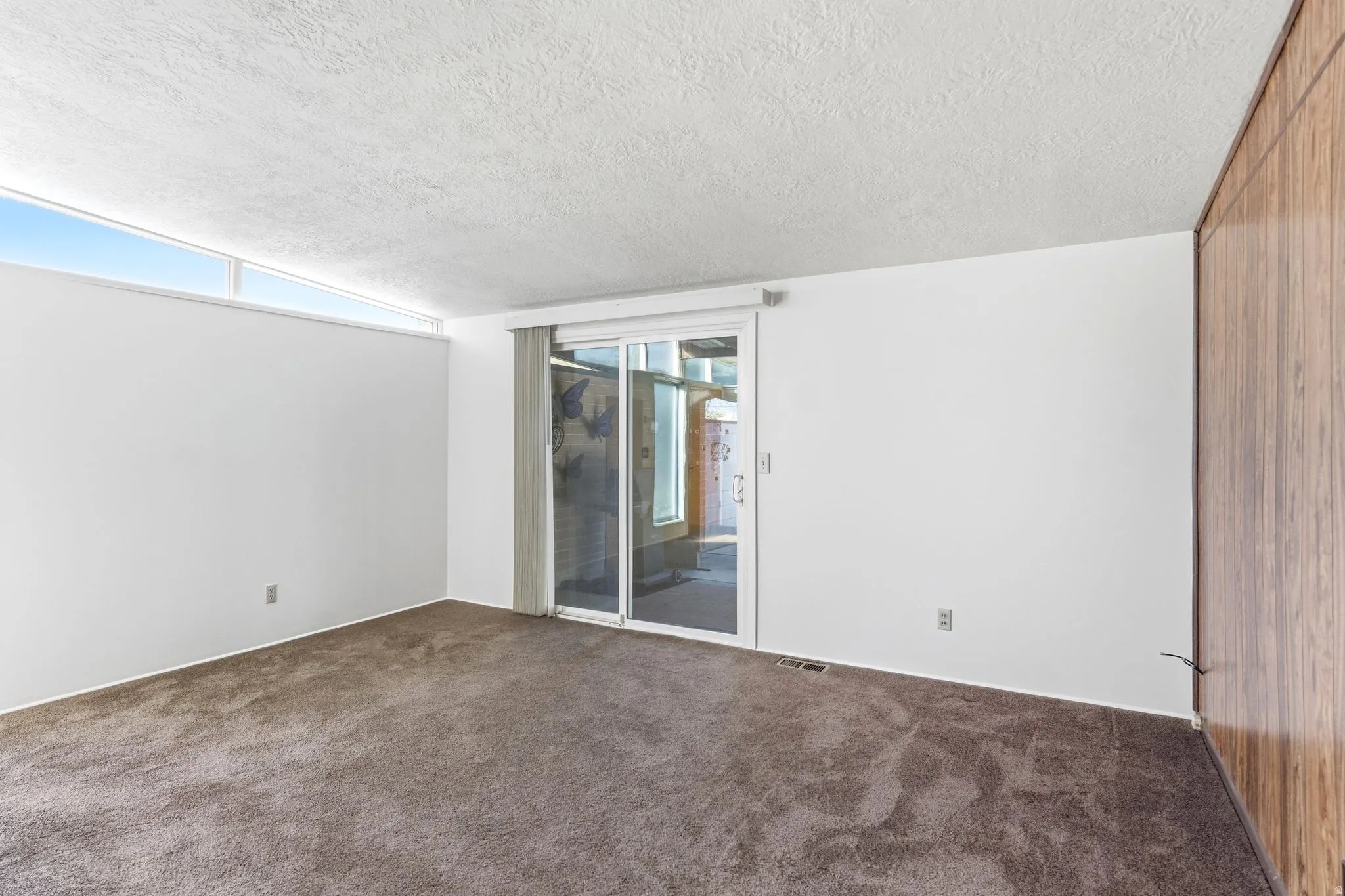 Unfurnished room featuring dark carpet