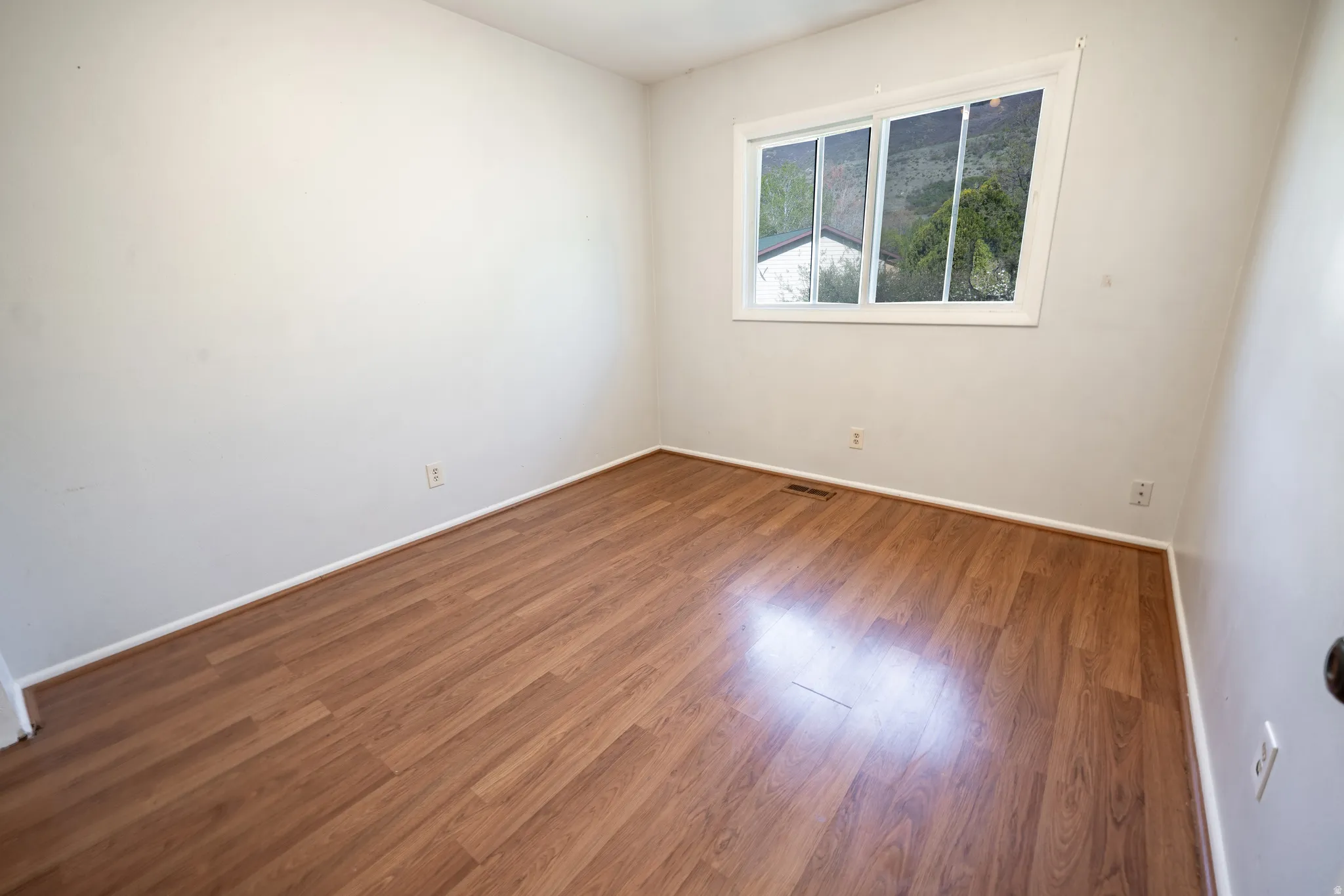 Empty room featuring wood finished floors and baseboards