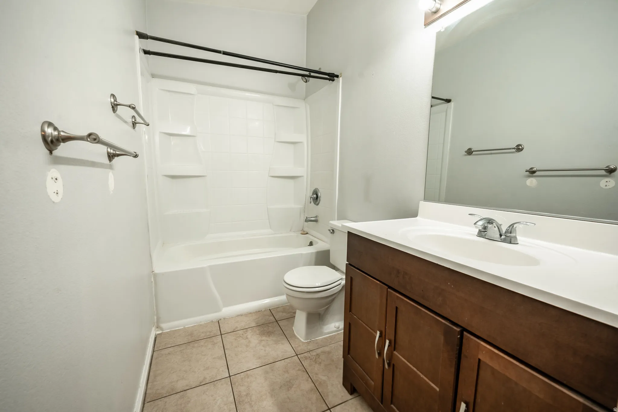 Bathroom featuring vanity, bathing tub / shower combination, and light tile patterned floors