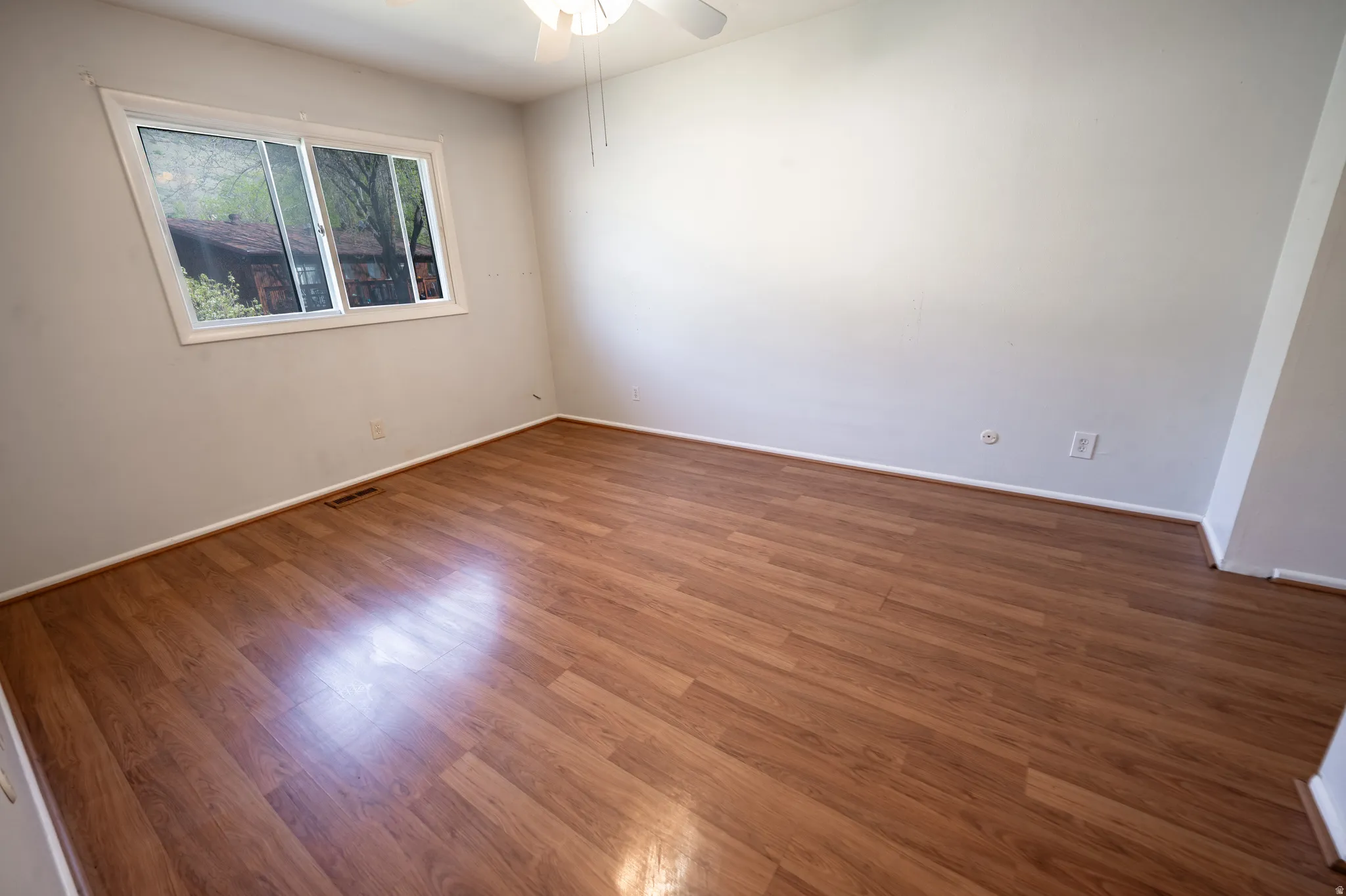 Spare room featuring wood finished floors and a ceiling fan