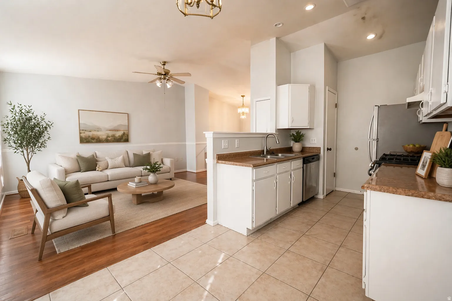 Virtual Staged - Kitchen featuring white cabinets, light tile patterned flooring, open floor plan, ceiling fan, and vaulted ceiling