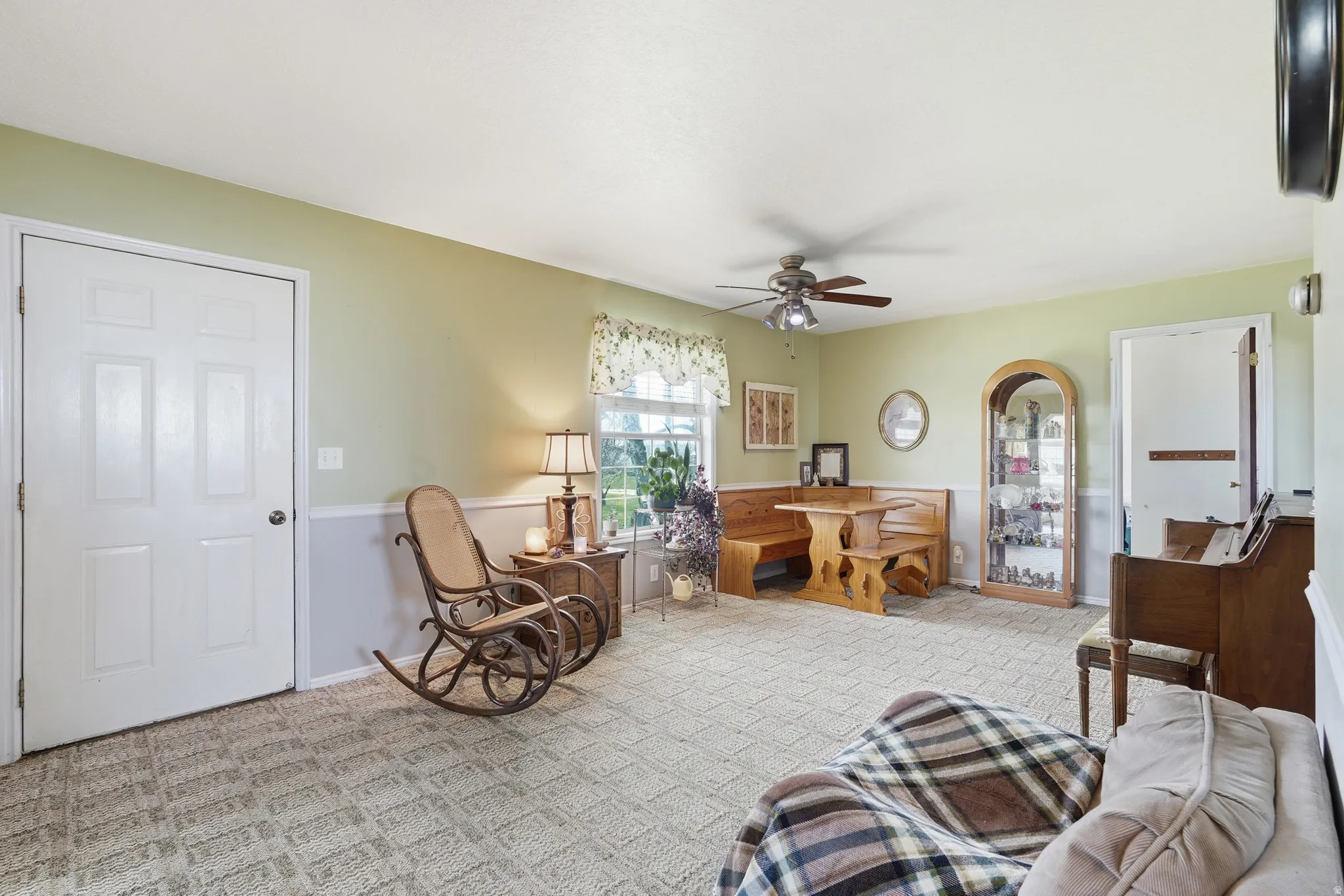 Sitting room featuring light colored carpet and ceiling fan