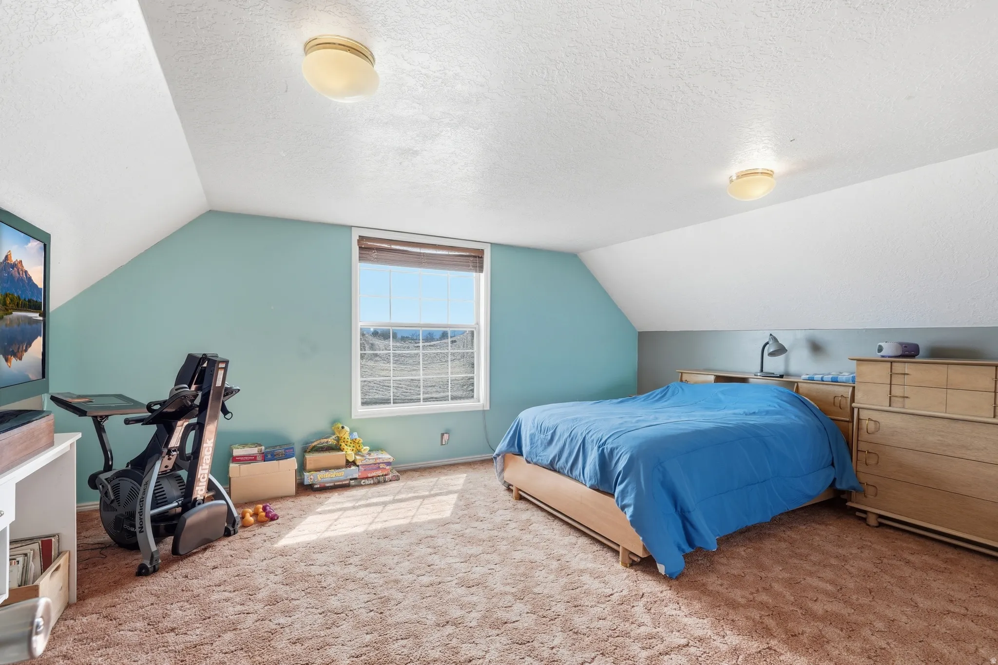 Carpeted bedroom featuring a textured ceiling and baseboards