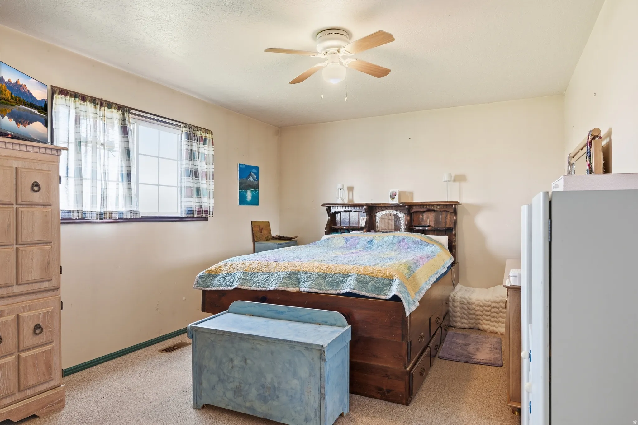 Bedroom with ceiling fan and light colored carpet
