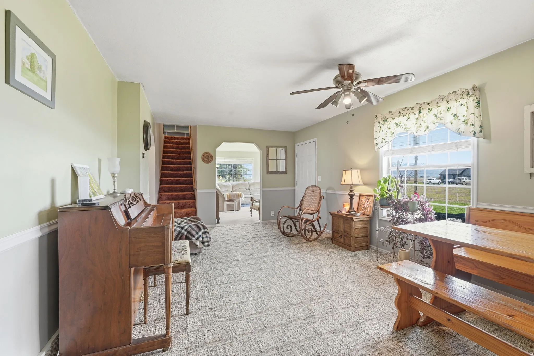 Sitting room featuring carpet floors, arched walkways, and a ceiling fan