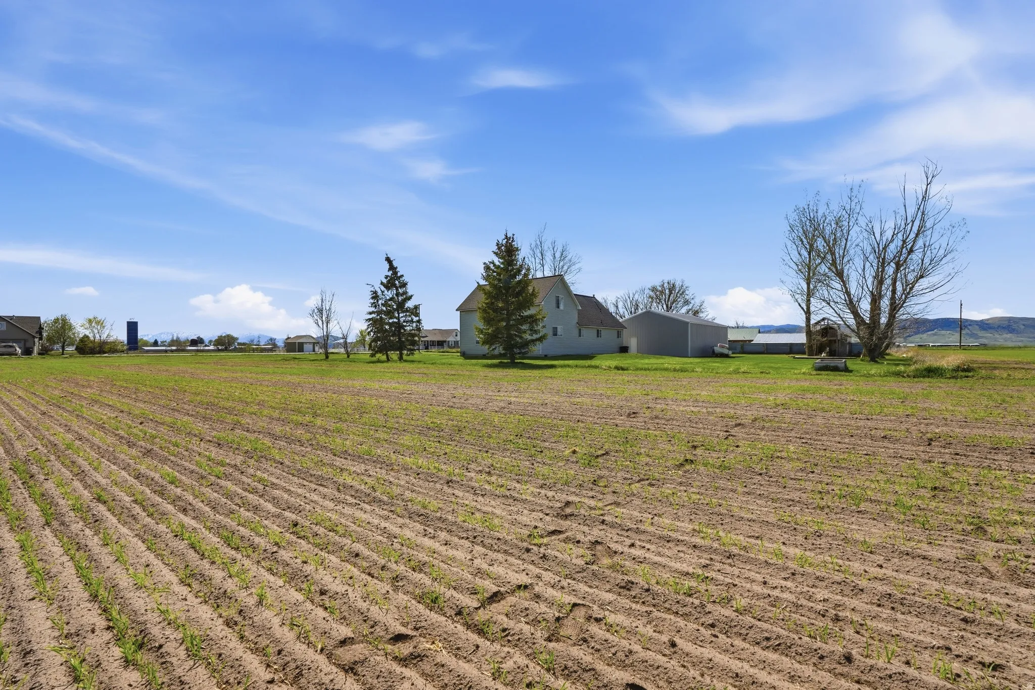 View of green lawn with agricultural plots and a view of countryside