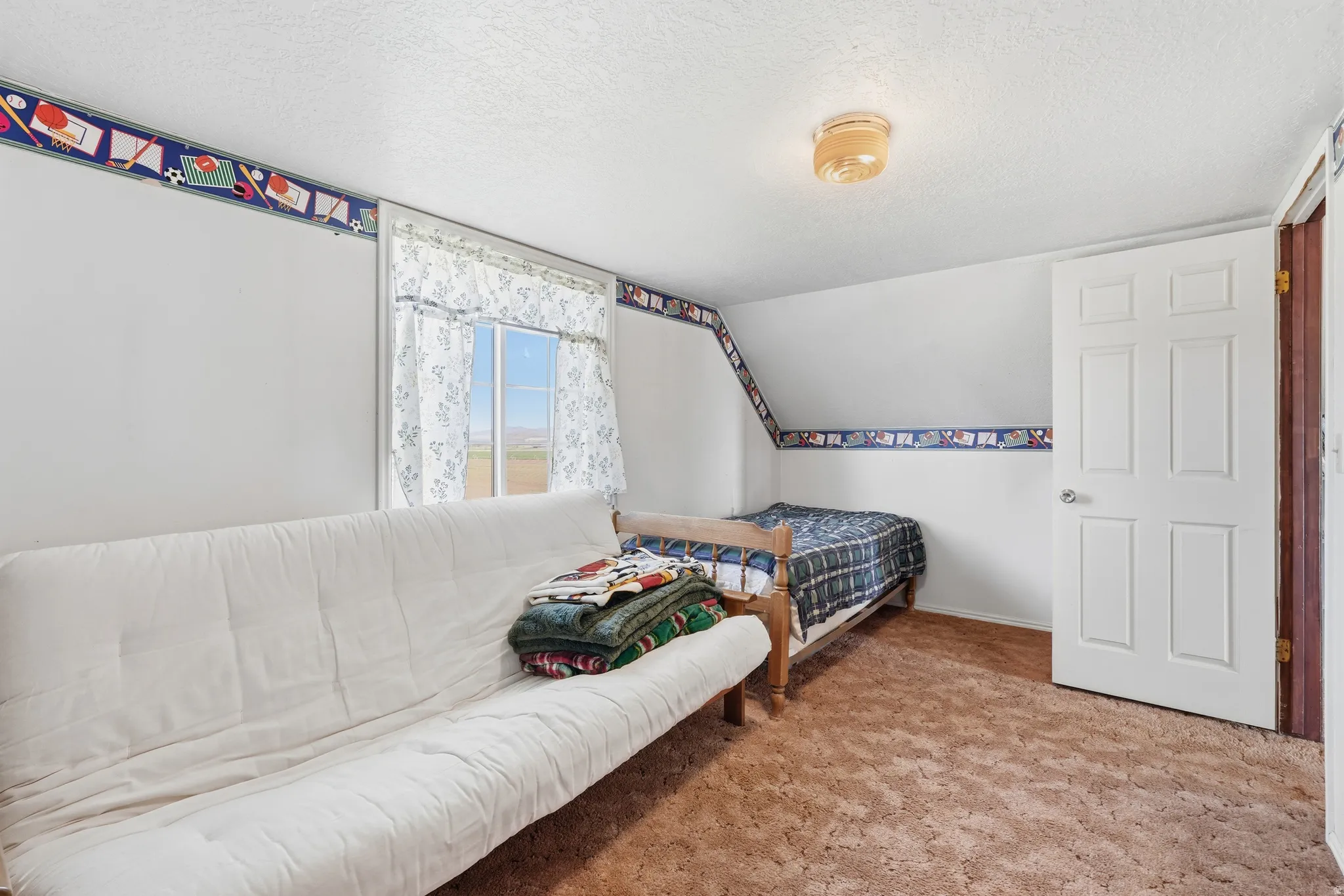 Bedroom featuring a textured ceiling and light carpet