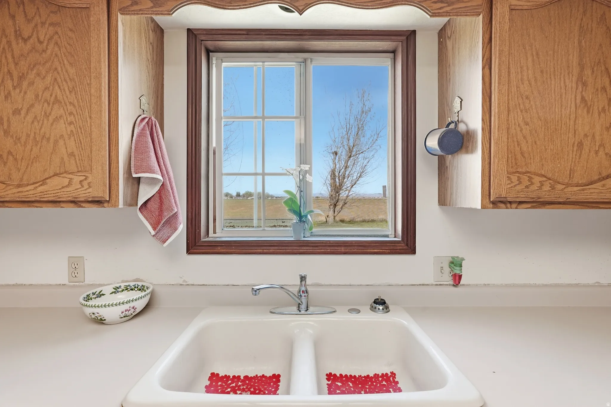 Kitchen view of light countertops and wood finish cabinets