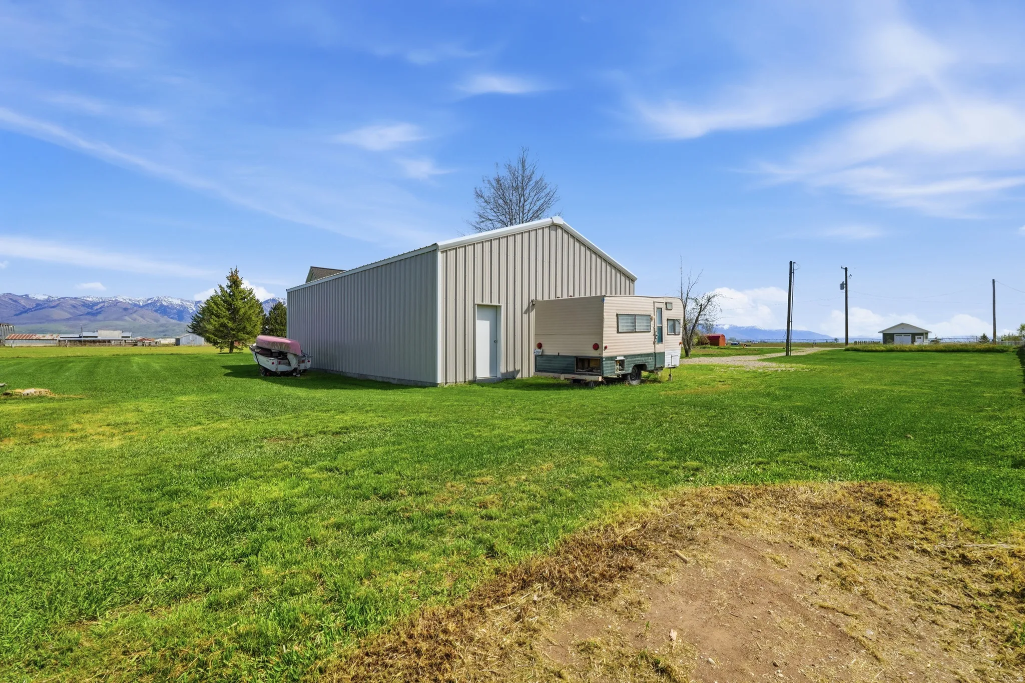 View of pole building featuring a mountain view and a lawn