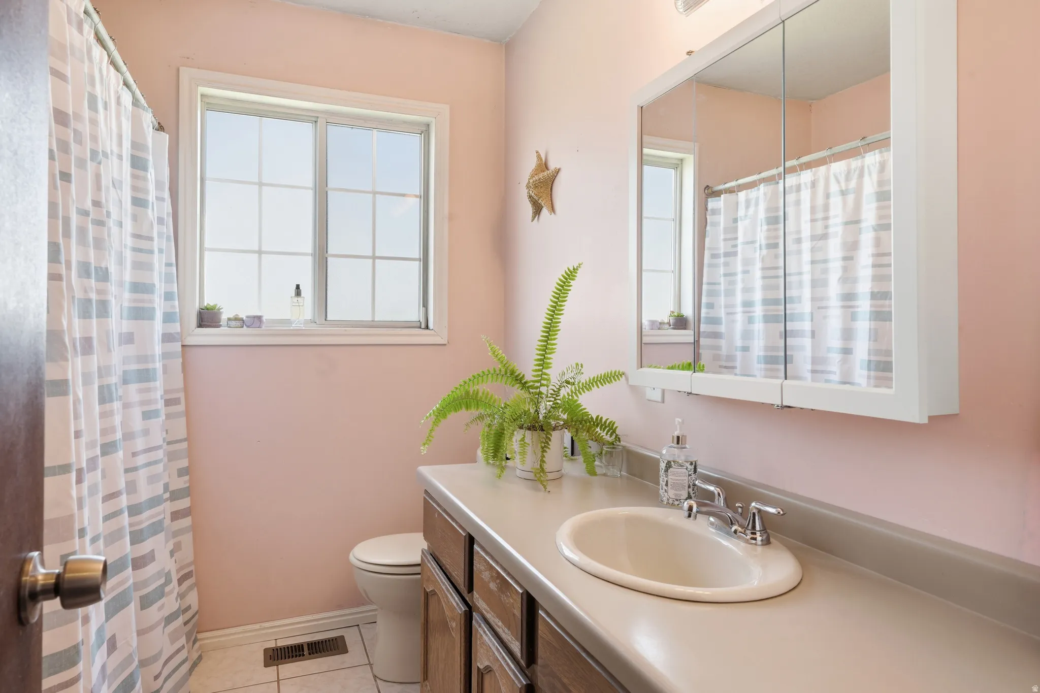 Bathroom with vanity, curtained shower, and light tile patterned floors