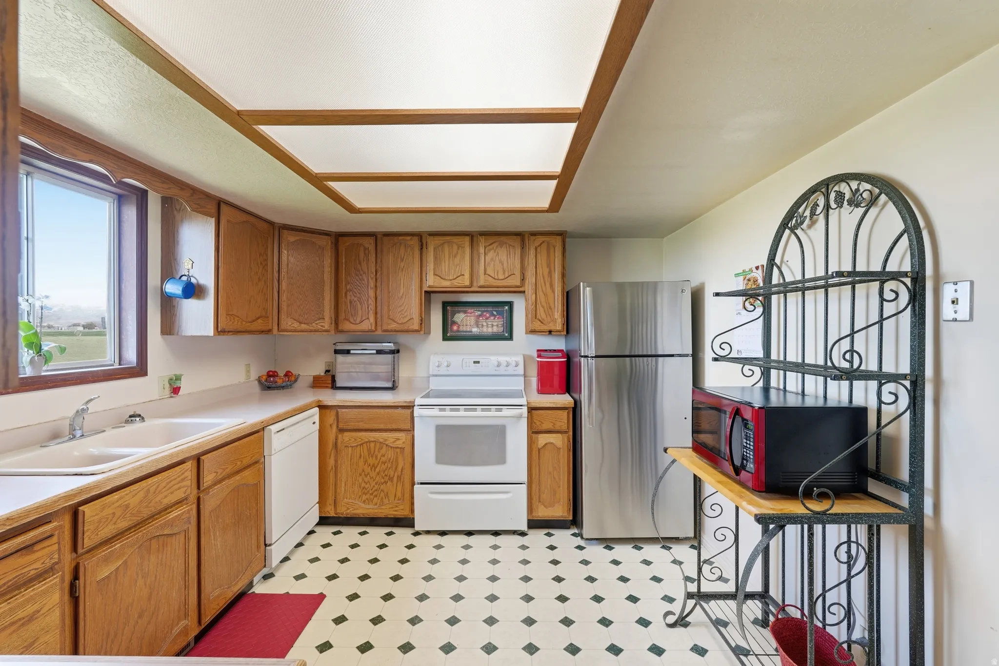 Kitchen featuring white appliances, wood finish cabinets, light countertops, and light floors