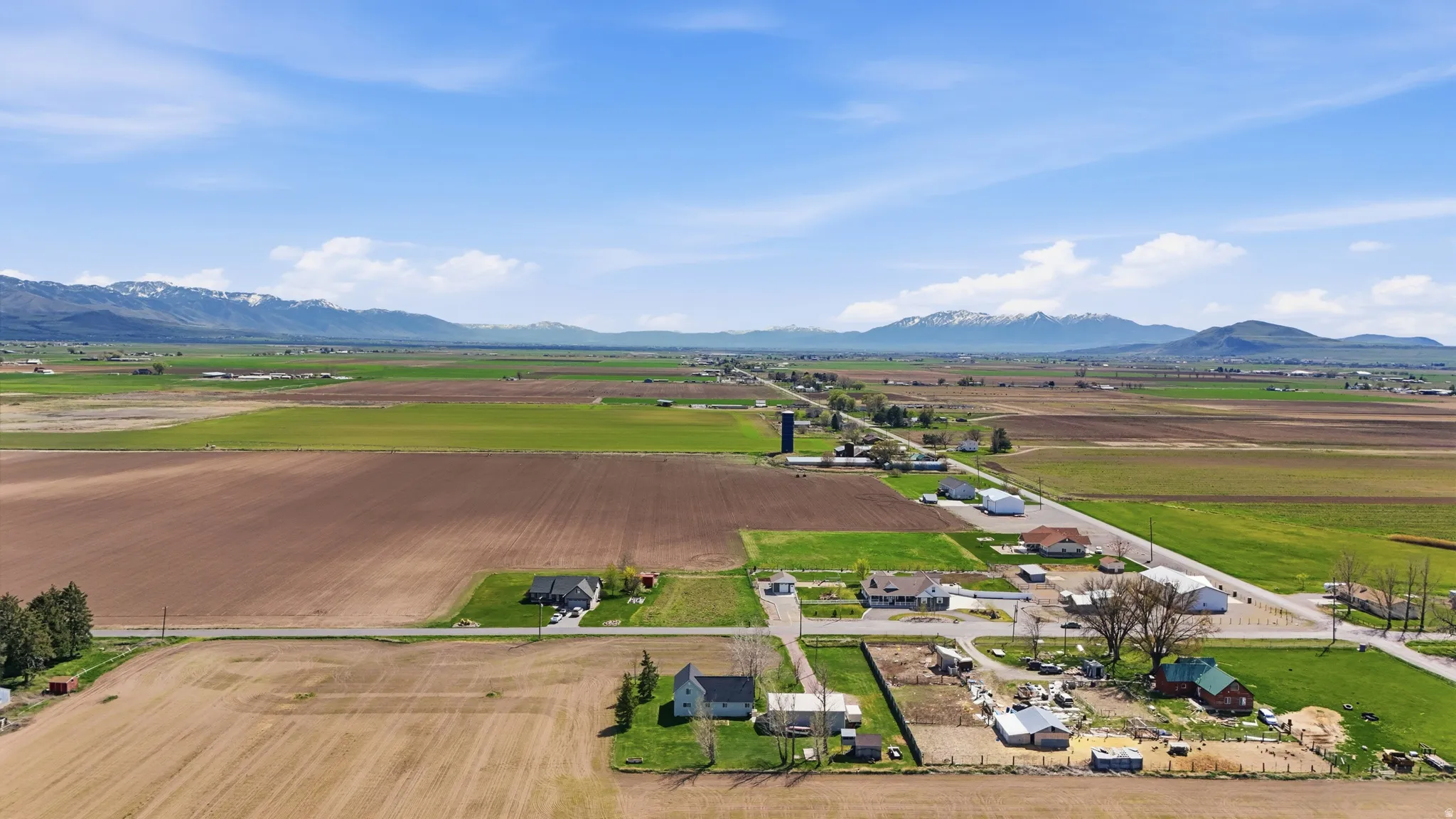Overview of rural landscape with large plots for crops and a mountain backdrop