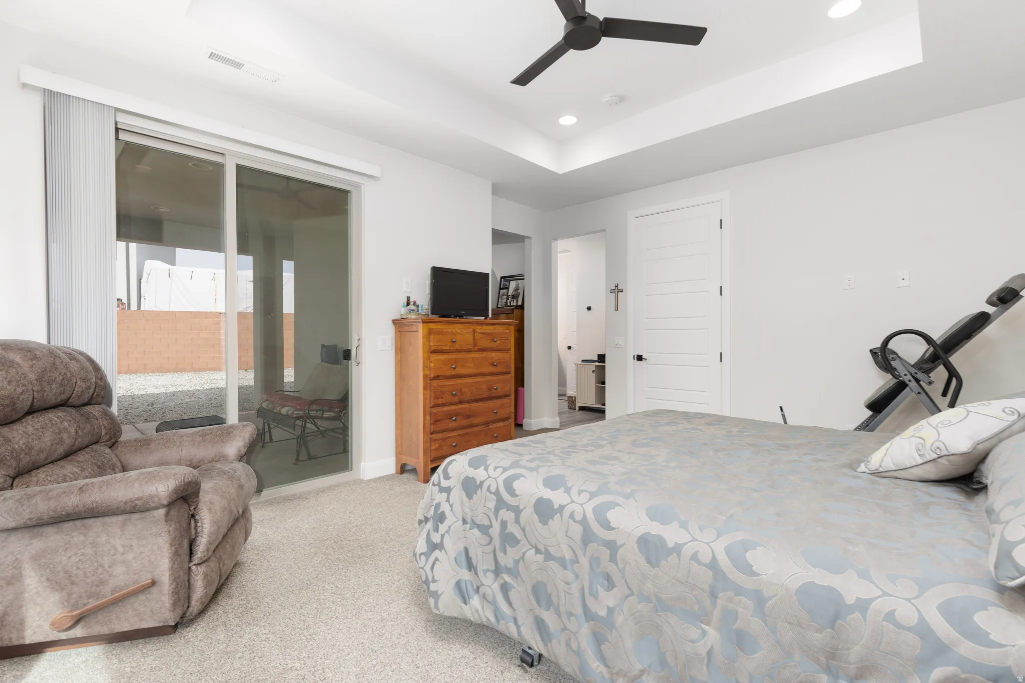 Bedroom featuring a raised ceiling, access to outside, light carpet, recessed lighting, and ceiling fan