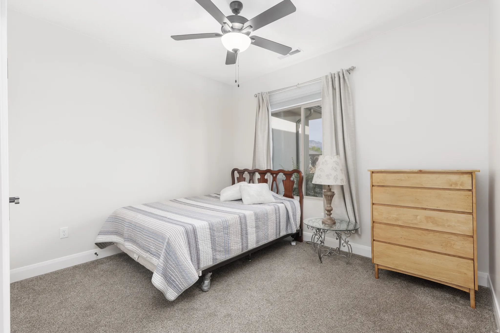 Carpeted bedroom featuring baseboards and ceiling fan