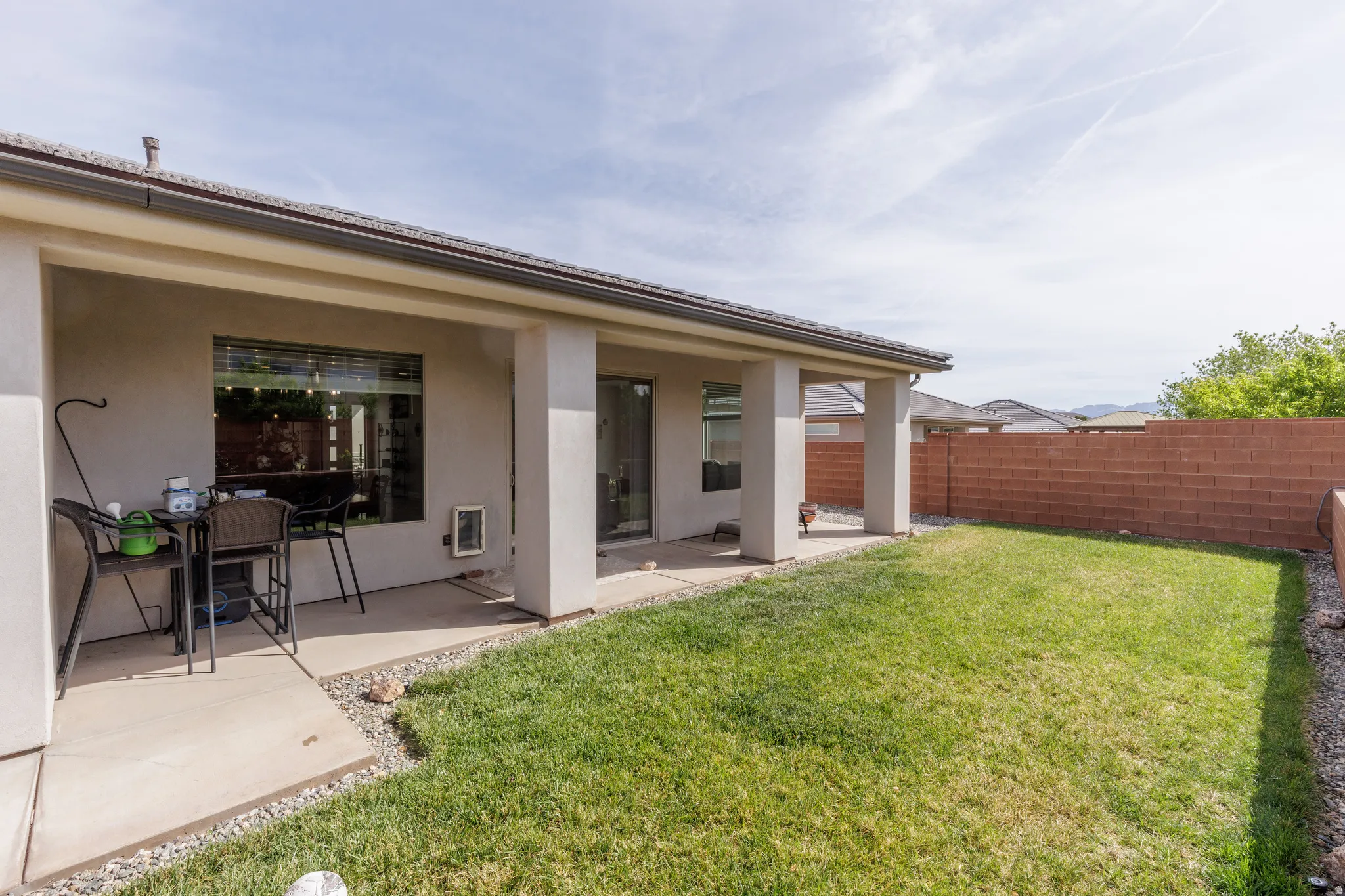 Rear view of property with stucco siding, a patio, and a fenced backyard