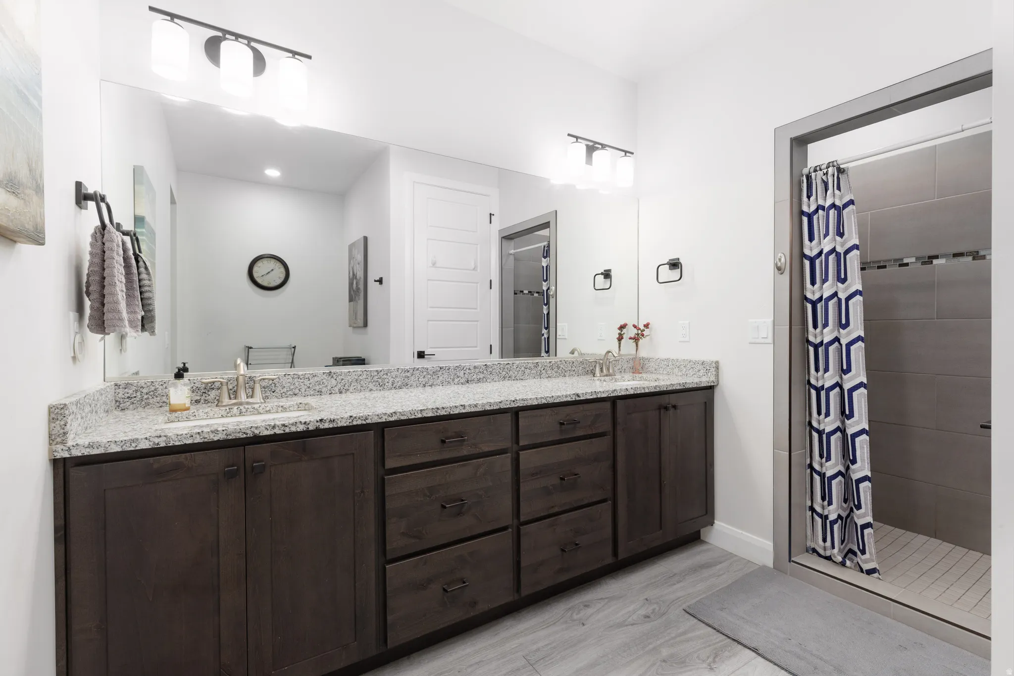 Full bathroom featuring double vanity and a stall shower